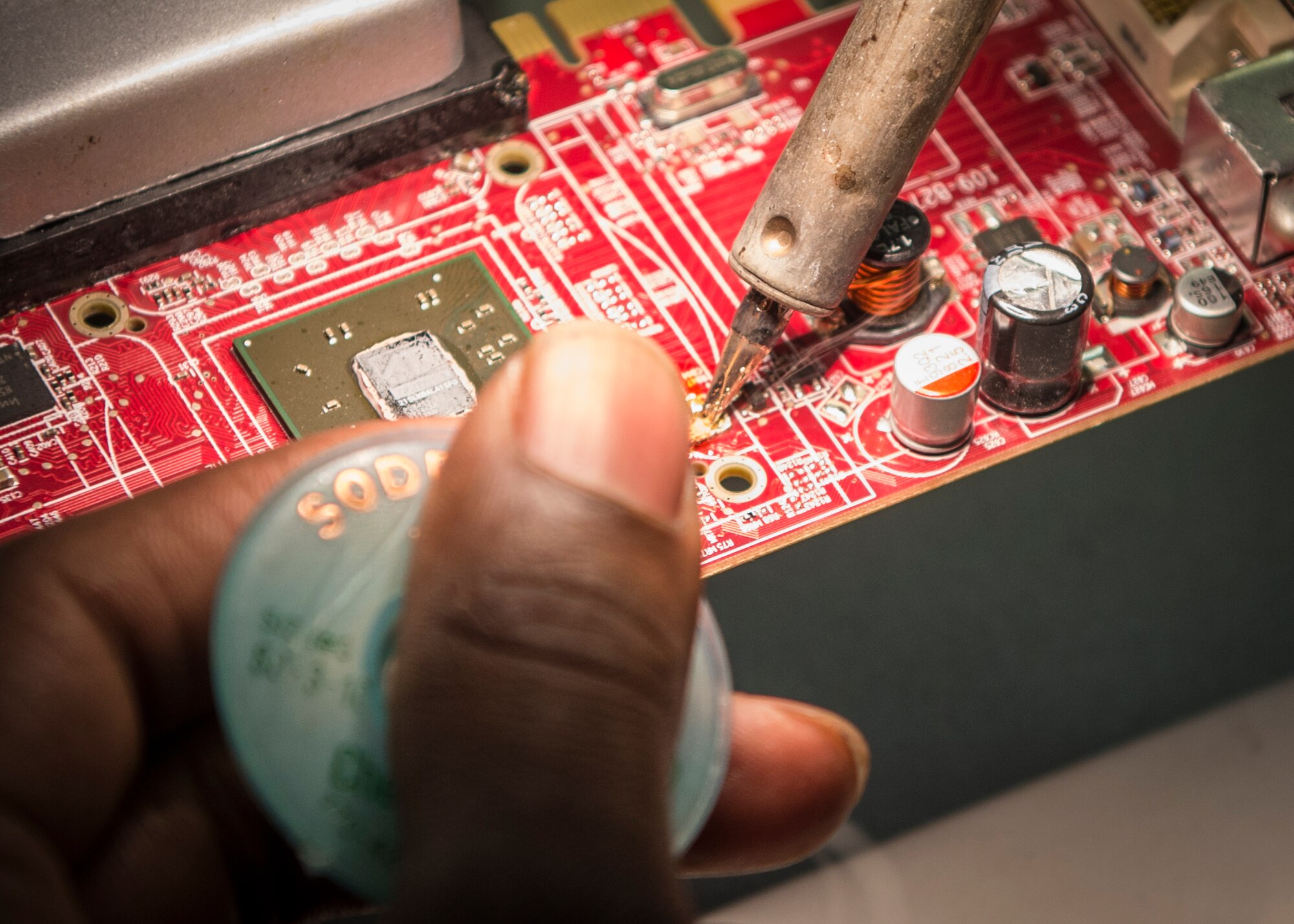 Staff Sgt. Mark Hawkins, Air Force Repair Enhancement Program lead technician, repairs a malfunctioning circuit board to avoid the cost of replacing the part at Holloman Air Force Base, N.M., July 1, 2015. AFREP saves the Air Force money by avoiding the cost of replacing malfunctioning equipment or hiring contractors to perform the repair. In less than a year, Hawkins has saved Holloman over $176,000 by repairing broken equipment. (U.S. Air Force photo by Senior Airman Aaron Montoya / Released)