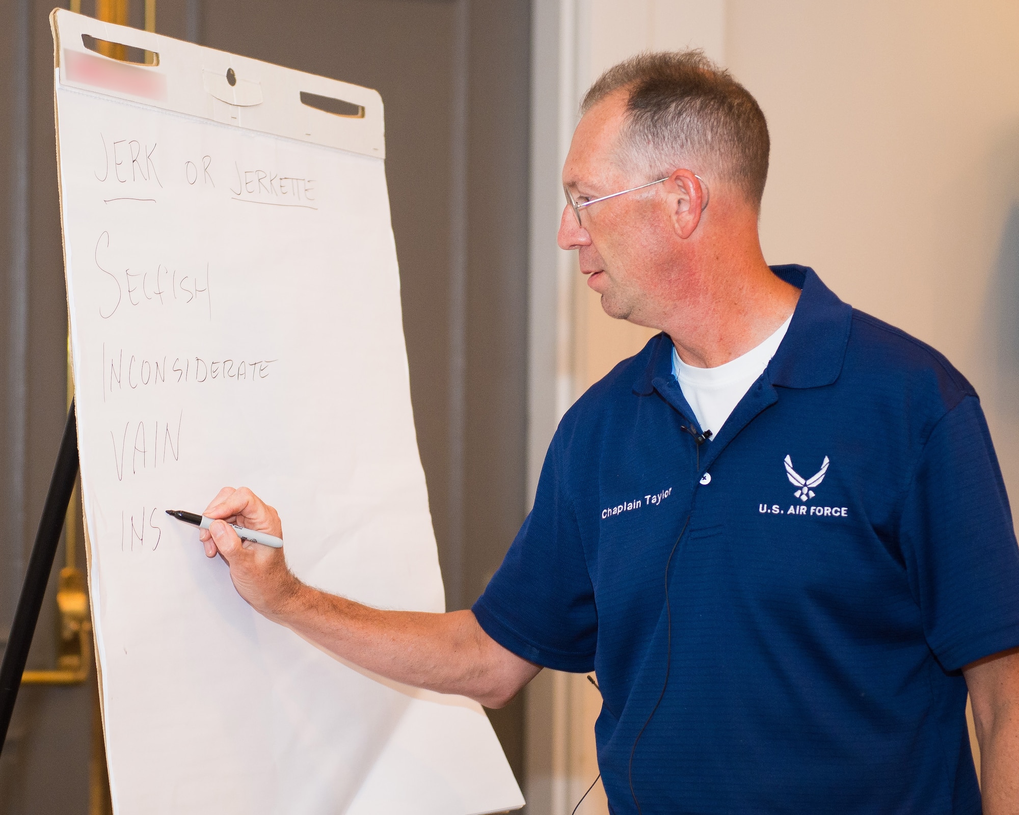 U.S. Air Force Maj. James Taylor, a chaplain and Strong Bonds instructor with the 116th Air Control Wing, Georgia Air National Guard, illustrates while teaching a class during the Strong Bonds singles retreat at the Sea Palms Resort, Saint Simons Island, Ga., June 26, 2015. The retreat, hosted by chaplains from the 116th Air Control wing, is a key component of the unit's resiliency program aimed at helping Airmen from Air National Guard units across Georgia to build relationships, learn to trust people, and hone their teambuilding skills. (U.S. Air National Guard photo by Senior Master Sgt. Roger Parsons/Released) (Portion of the photo blurred to removed name brand logo on presentation pad)