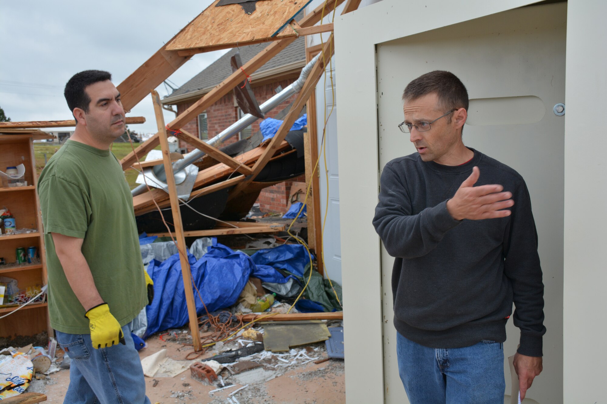 Curtis Swift, right, goes over what assistance he needs with Tech. Sgt. Joshua Tilse in getting debris cleared off his property in the aftermath of the May 6 tornado that hit his neighborhood in Bridge Creek. Sergeant Tilse said he’s known Mr. Swift for years and felt stepping up to be a good Wingman “just seemed like the right thing to do.” (Air Force photo by Darren D. Heusel/Released)