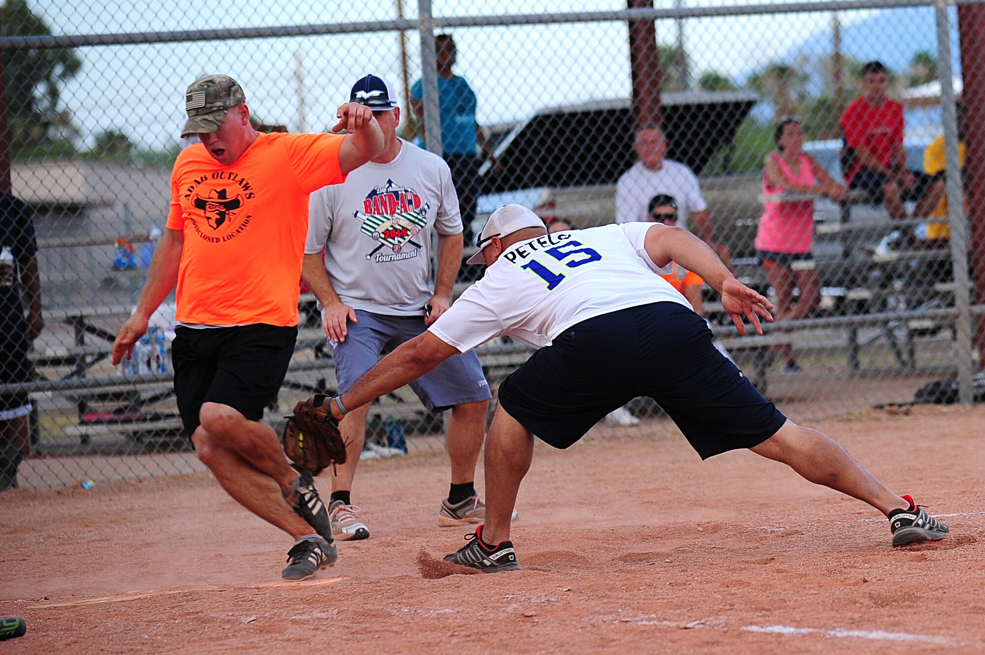 U.S. Air Force Staff Sgt. Jonathan Buck, 355th Civil Engineering Squadron pavement and equipment, reaches home base before being tagged by Senior Master Sgt. Robin Petelo, 355th Equipment Maintenance Squadron, during the Intramural Softball Championship game at Davis-Monthan Air Force Base Ariz., July 1, 2015. The run was a result of a base hit by Senior Airman Christopher Ladue, 355th CES firefighter, which tied the game to force extra innings. (U.S. Air Force photo by Airman 1st Class Chris Drzazgowski/Released)