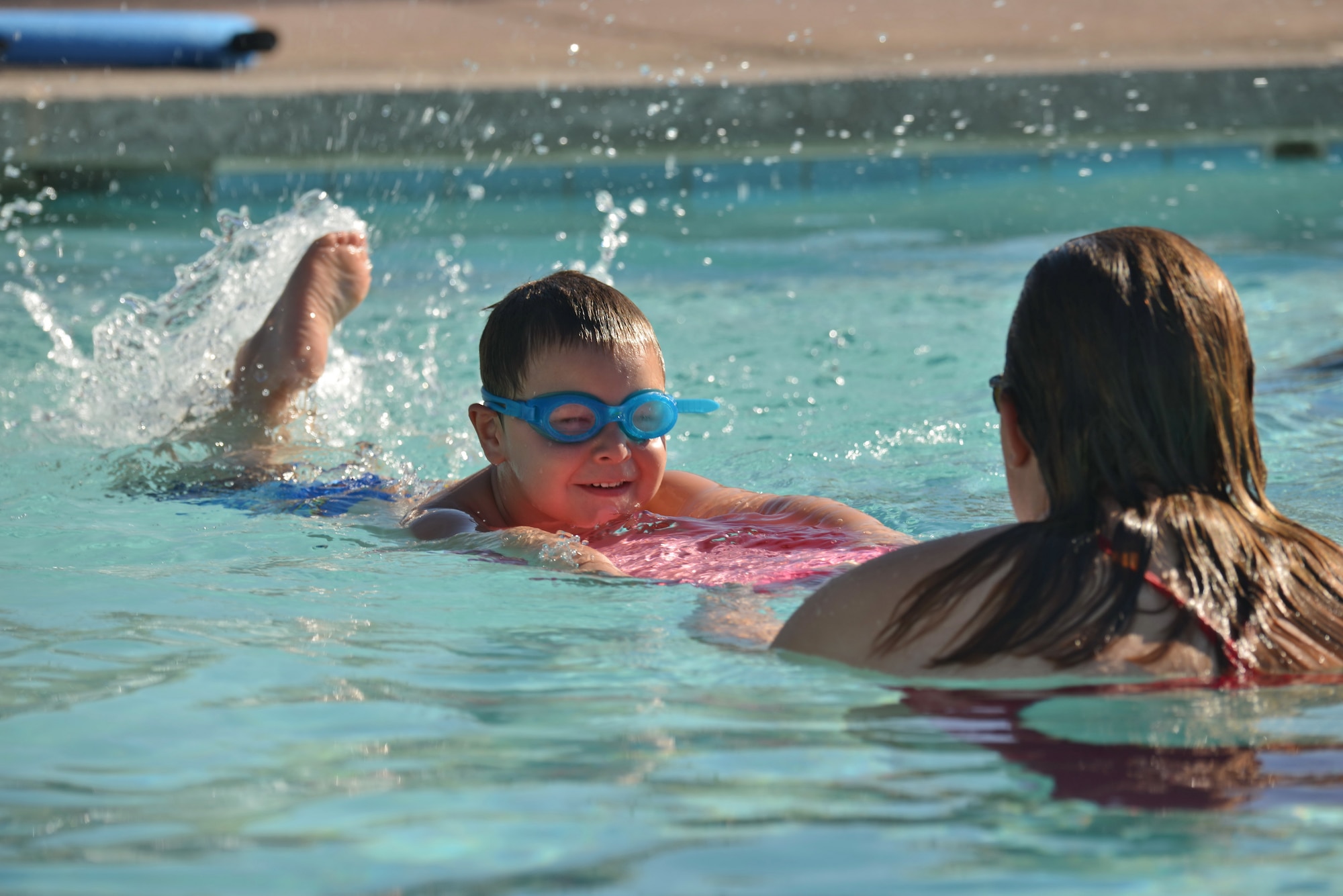Leanne Hancock, a swimming instructor at the base pool, works with 5-year-old Ajay Smukalla. Beginning July 13, Outdoor Recreation is offering morning and evening swim lessons for a variety of age ranges, from parent and tot sessions to advanced. (Photo by Jamie Burnett)