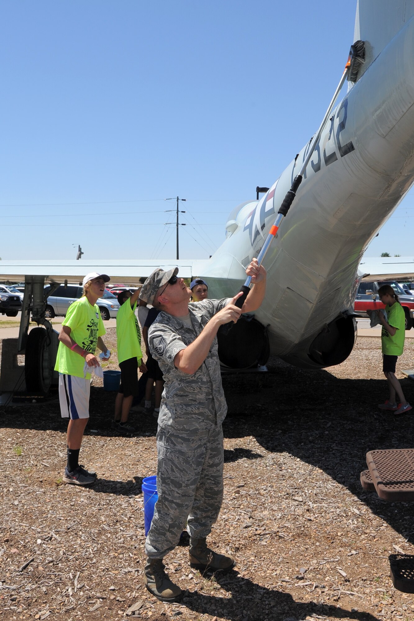 Master Sgt. Eric Mayes, 388th Maintenance Group executive assistant, scrubs the tail flash of an aircraft during the Hill Aerospace Museum service project June 19. Mayes and several other 388th Fighter Wing Airmen mentored young volunteers as they landscaped the museum grounds and washed airplanes. (U.S. Air Force/Todd Cromar)