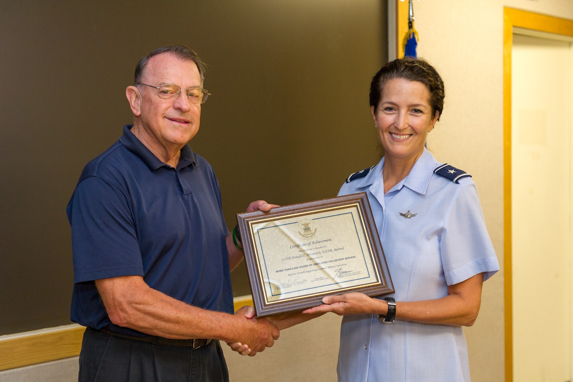 Brig. Gen. Nina Armagno, 45th Space Wing commander, presents Don Winterich, Project Emeritus volunteer and military veteran, with a Certificate of Achievement for dedicating over 5,000 hours of volunteer service, July 1, 2015, at Patrick Air Force Base, Fla. Winterich is the site coordinator of the PAFB Volunteer Income Tax Assistance (VITA) program, which has helped save over $300 thousand in tax preparation fees and had approximately $2 million in refunds. (U.S. Air Force photo/Cory Long) (Released) 
