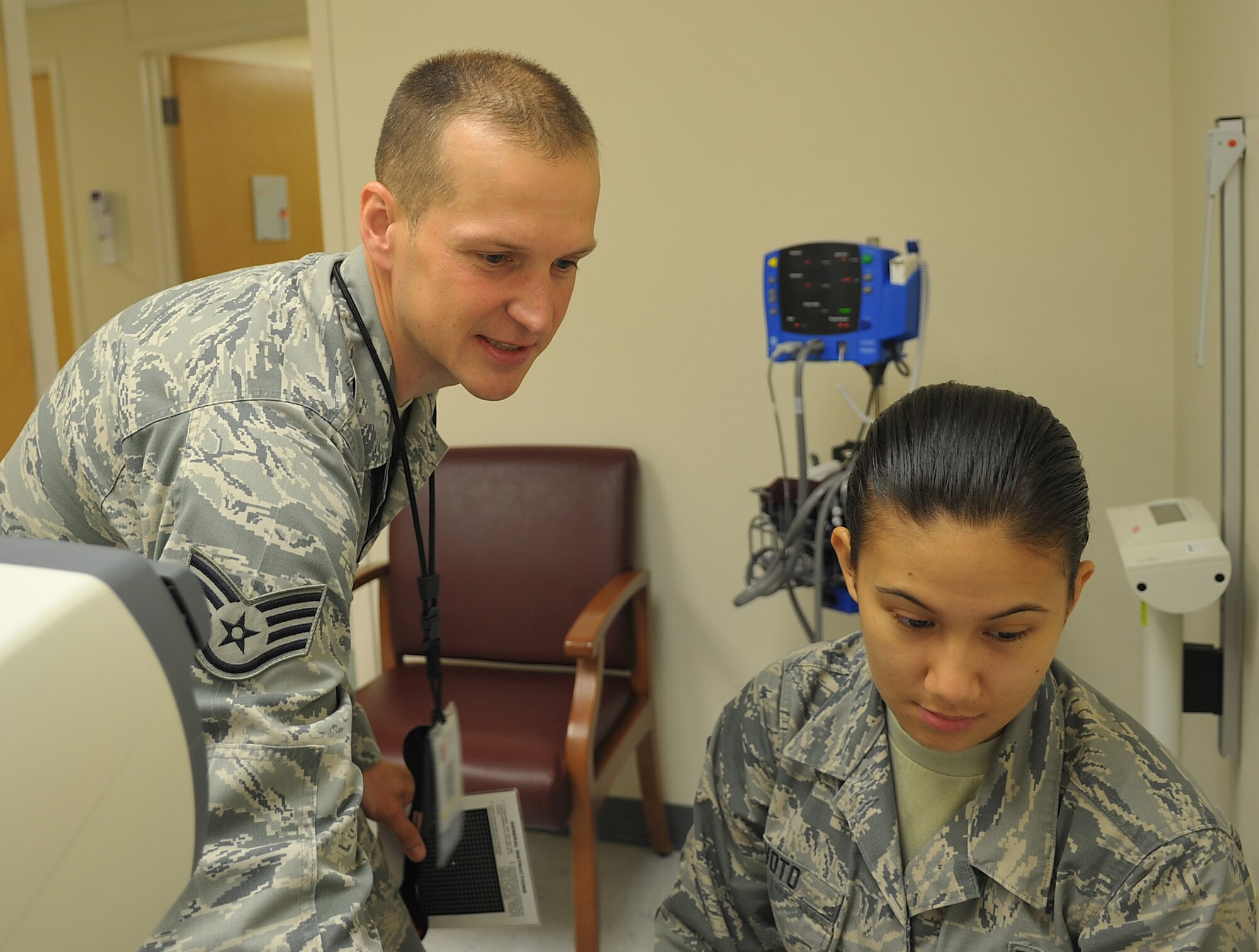 Staff Sgt. Aliaksei Krasouski, a 78th Aerospace Medical Services technician, consults with Airman 1st Class Cheree Voto, 78th Medical Support Squadron technician, after conducting an eye exam.  (U.S. Air Force photo by Misuzu Allen)
