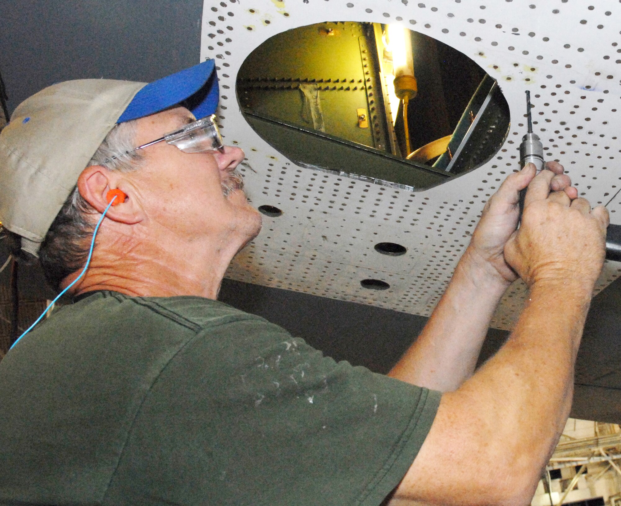 Donald Shirreffs, a 559th Aircraft Maintenance Squadron sheet metal mechanic, uses a small drill to install a pointer tracker assembly on the aircraft. (U.S. Air Force photo by Misuzu Allen)