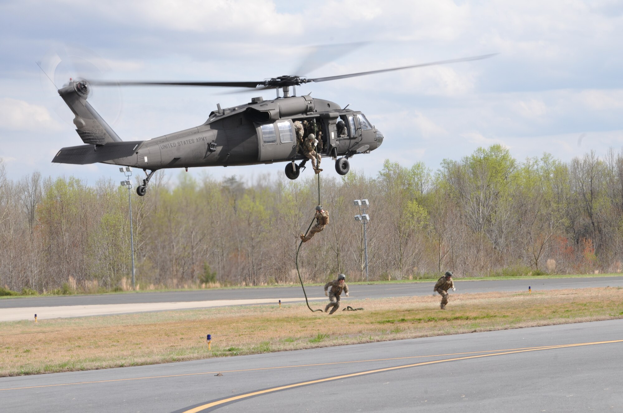 Members of the 118th Air Support Operations Squadron conduct FAST rope insertions at Stanly County Airport, New London, N.C., from an UH-60 Blackhawk helicopter of Company C, 1-131 AVN; North Carolina Army National Guard, April 8, 2014. Fast-roping, also known as Fast Rope Insertion Extraction System (FRIES) is a technique for descending a thick rope. It is useful for deploying troops from a helicopter in places where the helicopter itself cannot touchdown. The joint training mission allows both air and ground crews to hone their skills in planning and executing an air assault. (U.S. Air National Guard photo by Master Sgt. Patricia F. Moran, 145th Public Affairs/Released)