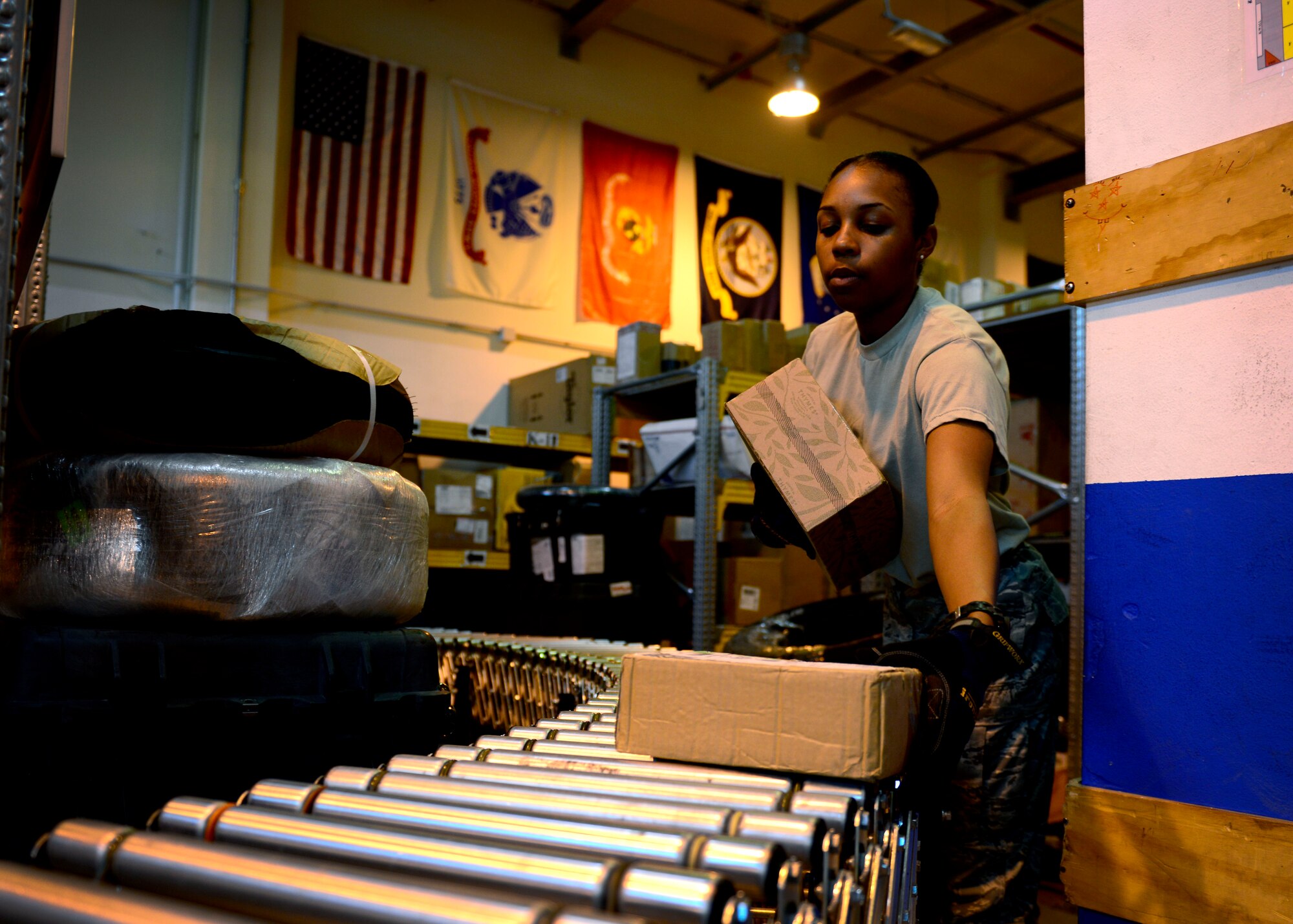 U.S. Air Force Airman 1st Class Keasha Carter, 31st Communications Squadron postal clerk, unloads mail, July 1, 2015, at Aviano Air Base, Italy. During 2014, the Aviano Post Office received more than 176, 800 parcels for service members, dependents and civilians assigned to the installation. (U.S. Air Force photo by Senior Airman Areca T. Wilson/Released)
