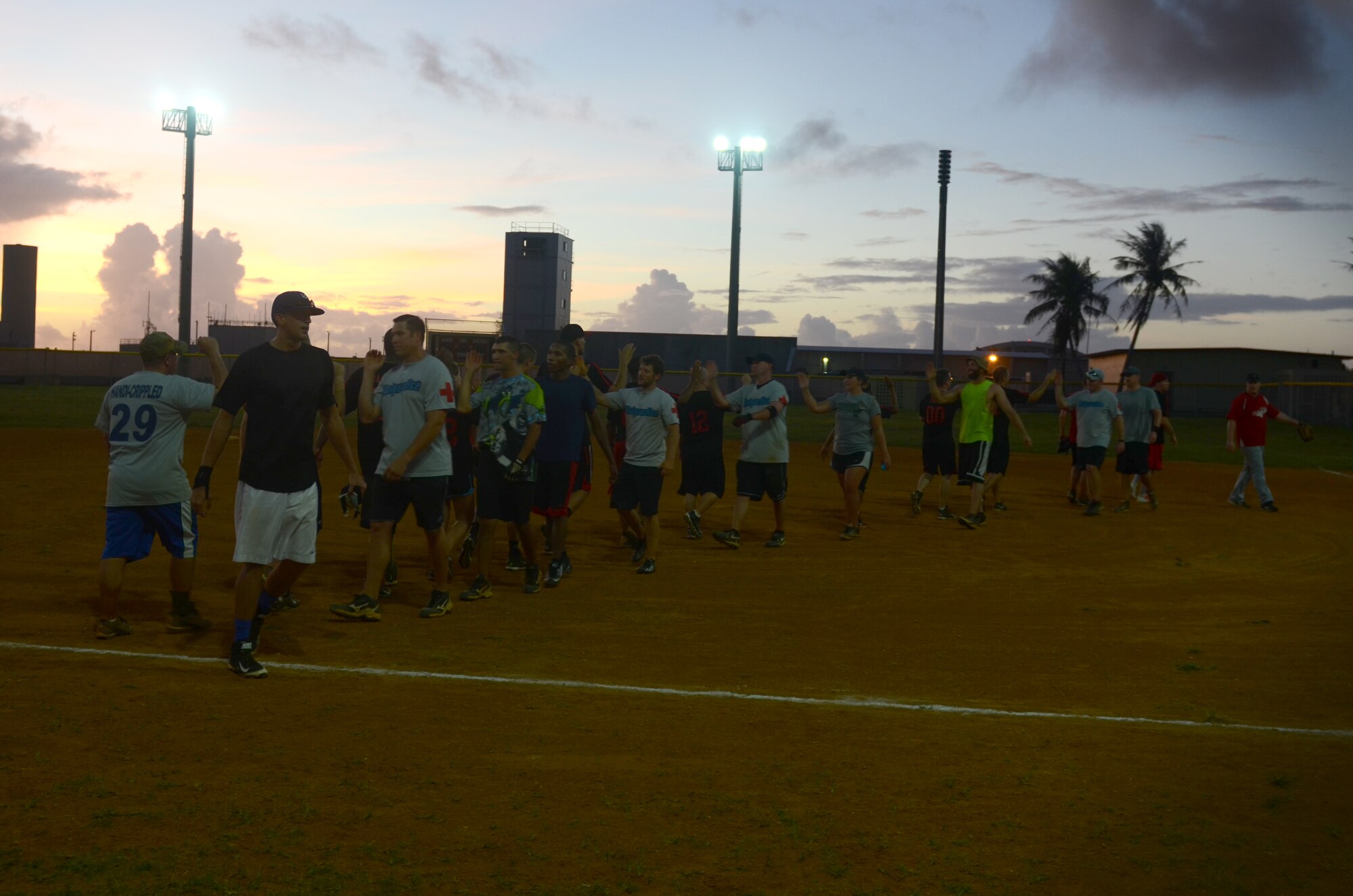 The 36th Medical Operations Squadron and the 36th Contracting Squadron give each high-fives during an intramural softball game July 1, 2015, at Andersen Air Force Base, Guam. The 36th CS won the game with a final score of 19-17.  (U.S. Air Force photo by Airman 1st Class Alexa Ann Henderson/Released)