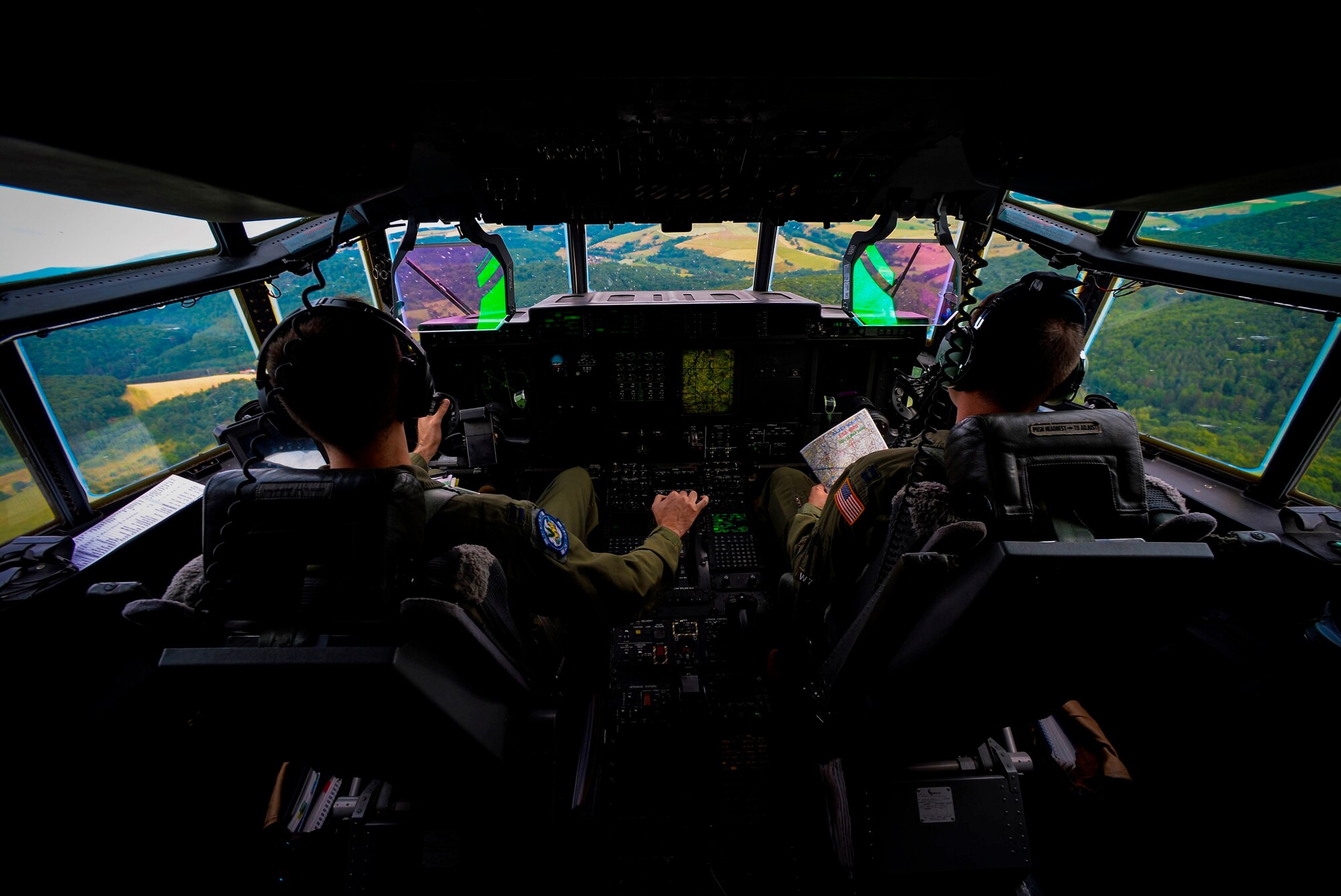 Capts. Sean McKee (right) and  Jonathan Recor, C-130J Super Hercules pilots assigned to the 37th Airlift Squadron, fly a C-130J during an orientation flight for German local nationals June 29, 2015, at Ramstein Air Base, Germany. McKee and Recor flew more than 20 German locals 500 feet off the ground, performing maneuvers and giving them a glimpse of the U.S. Air Force side of the mission at Ramstein. (U.S. Air Force photo/Senior Airman Nicole Sikorski)
