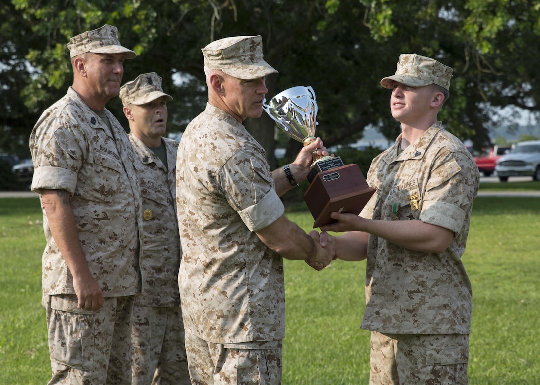 Major Gen. Brian D. Beaudreault, the commanding general of 2nd Marine Division, awards the Rifle Squad Competition trophy to Sgt. Jaymes L. Chambless, the squad leader of the winning squad from Alpha Company, 1st Battalion, 2nd Marine Regiment during an award ceremony aboard Camp Lejeune, N.C., July 1, 2015. The squad was declared the best rifle squad in the 2nd Marine Division after competing in the Infantry Rifle Squad Competition, a three-day physical and mental challenge that pushed the Marines to their limits and tested their abilities to work together as a cohesive unit. (U.S. Marine Corps photo by Cpl. Michelle Reif/Released)