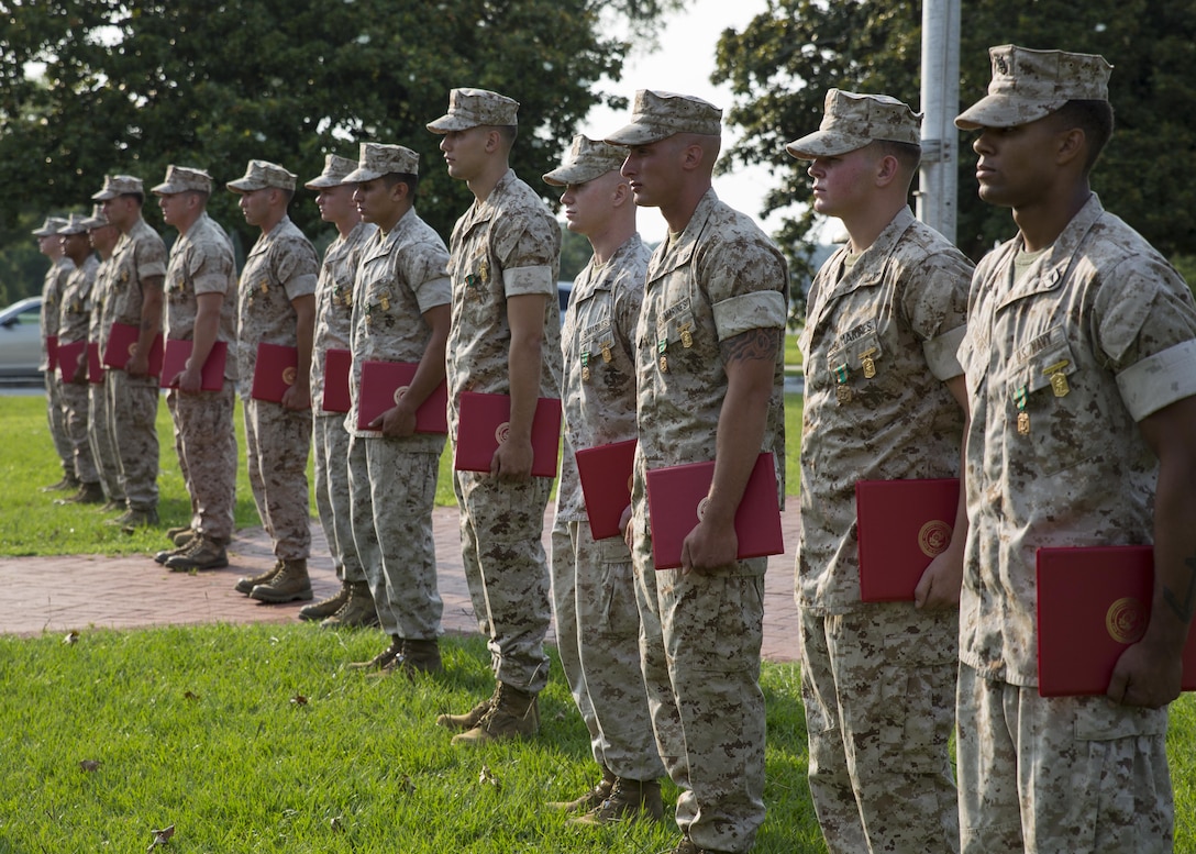 The winning rifle squad from Alpha Company, 1st Battalion, 2nd Marine Regiment, stands to receive applause after being pinned with a Navy and Marine Corps Achievement Medal and the Infantry Rifle Squad Competition Medal during an award ceremony aboard Camp Lejeune, N.C., July 1, 2015. The squad was declared the best rifle squad in the 2nd Marine Division after competing in the Infantry Rifle Squad Competition, a three-day physical and mental challenge that pushed the Marines to their limits and tested their abilities to work together as a cohesive unit. (U.S. Marine Corps photo by Cpl. Michelle Reif/Released)