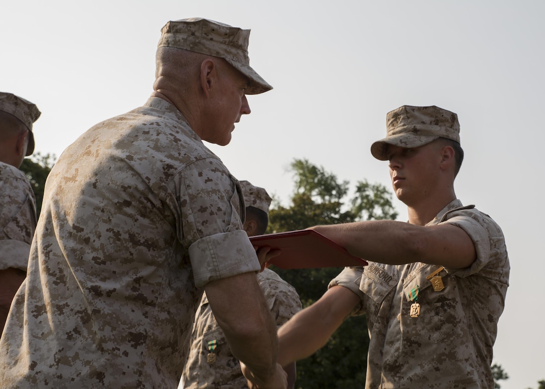 Major Gen. Brian D. Beaudreault, the commanding general of 2nd Marine Division, awards a member of Alpha Company, 1st Battalion, 2nd Marine Regiment a Navy and Marine Corps Achievement Medal and the Infantry Rifle Squad Competition Medal during an award ceremony aboard Camp Lejeune, N.C., July 1, 2015. The squad was declared the best rifle squad in the 2nd Marine Division after competing in the Infantry Rifle Squad Competition, a three-day physical and mental challenge that pushed the Marines to their limits and tested their abilities to work together as a cohesive unit. (U.S. Marine Corps photo by Cpl. Michelle Reif/Released)