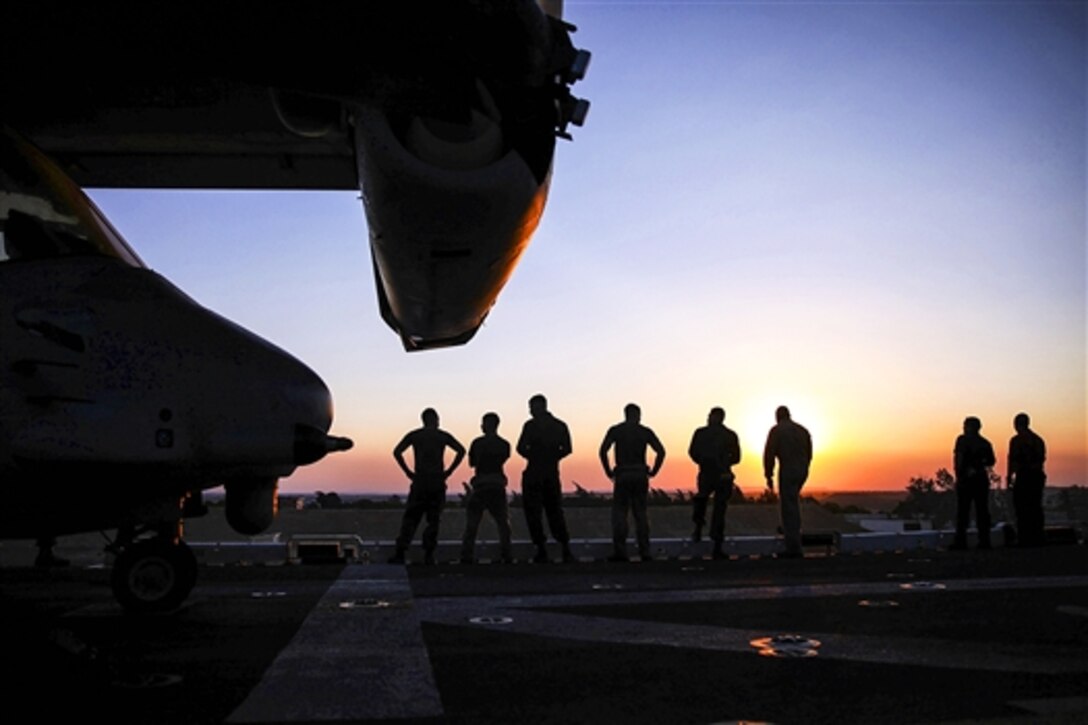 U.S. Marines look at the sunset as the amphibious assault ship USS Iwo Jima  transits through the Suez Canal, Egypt, June 22, 2015. The Marines are assigned to the 24th Marine Expeditionary Unit, which is deployed on the USS Iwo Jima and the Iwo Jima Amphibious Ready Group to support  U.S. national security interests in the U.S. 6th Fleet area of operations.