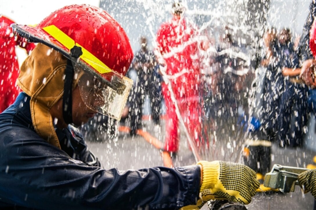 U.S. Navy Petty Officer 1st Class Tristan Bugayong practices pipe patching during a general quarters drill aboard the amphibious transport dock ship USS Anchorage in the Gulf of Aden, June 29, 2015. The Anchorage is supporting maritime security operations and theater security cooperation efforts in the U.S. 5th Fleet area of operations.
