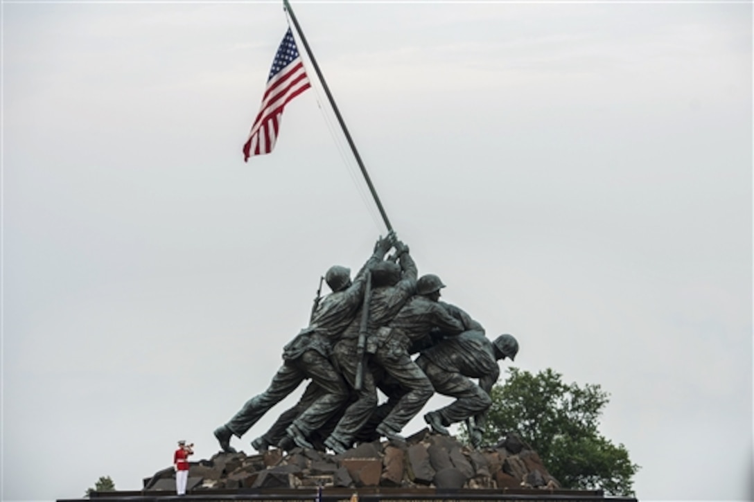 A Marine bugler plays taps during the Marine Corps Sunset Parade at the Iwo Jima Memorial in Arlington, Va., June 30, 2015, where Defense Secretary Ash Carter was the guest of honor.