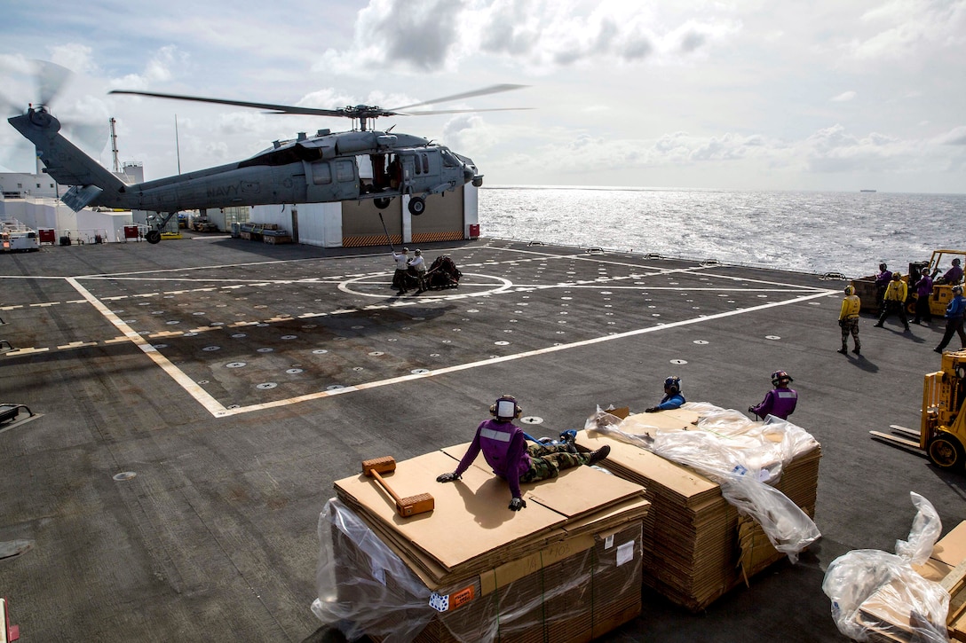 U.S. Navy sailors on the flight deck of the hospital ship USNS Mercy secure a cargo sling to an SH-60S Seahawk from Helicopter Sea Combat Squadron 25 during an underway replenishment in the Solomon Sea, June 26, 2015. The Mercy was participating in Pacific Partnership 2015.