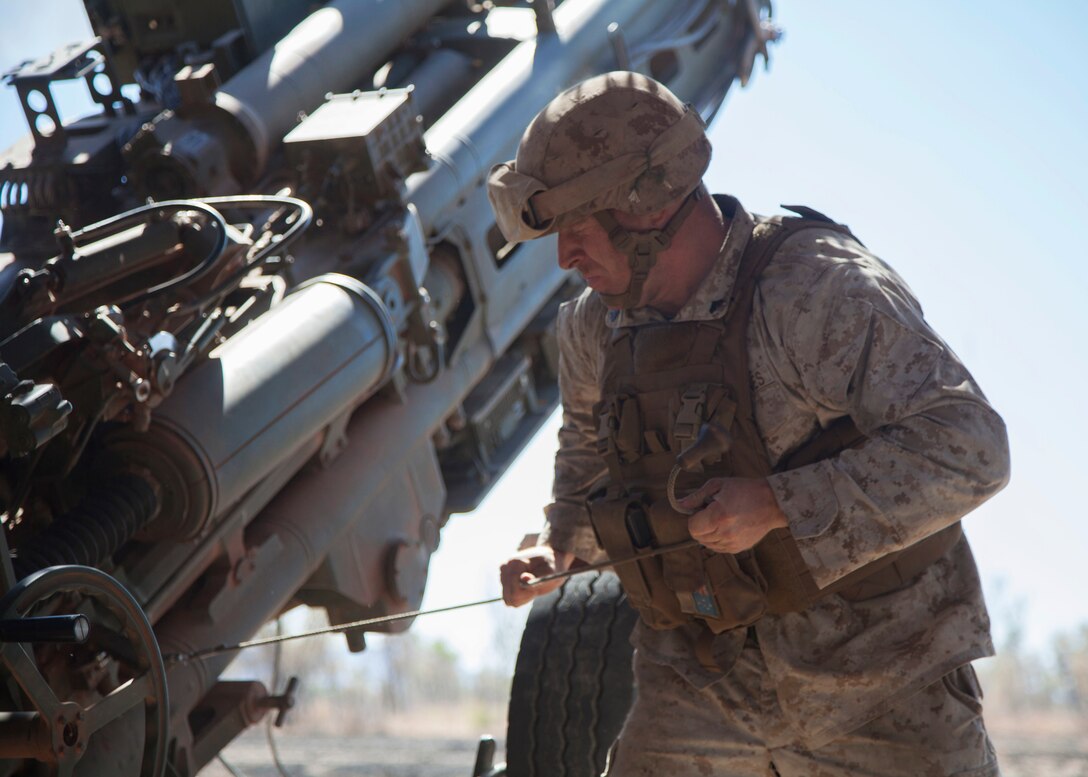 U.S. Marine Corps Cpl. Shane McCarthy pulls the lanyard of an M777A2 lightweight 155 mm howitzer to fire a projectile in support of an air assault course on Bradshaw Field Training Area, Northern Territory, Australia, June 29, 2015.