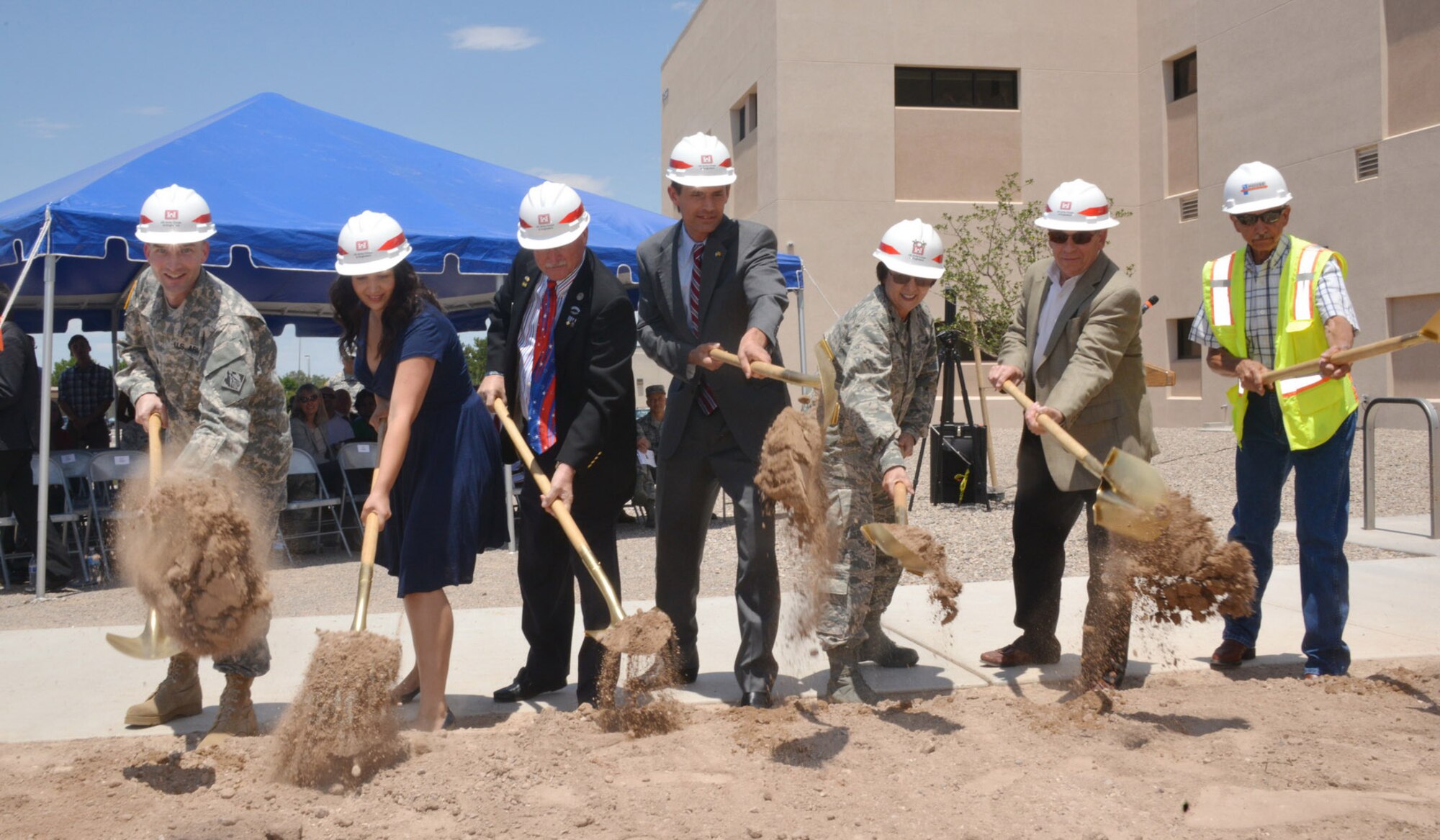 A group of dignitaries, including Sen. Martin Heinrich, center, and Maj. Gen. Sandra Finan, third from the left, commander of the Air Force Nuclear Weapons Center at Kirtland, fling dirt at a ground breaking ceremony.  (Photo by Dennis Carlson)