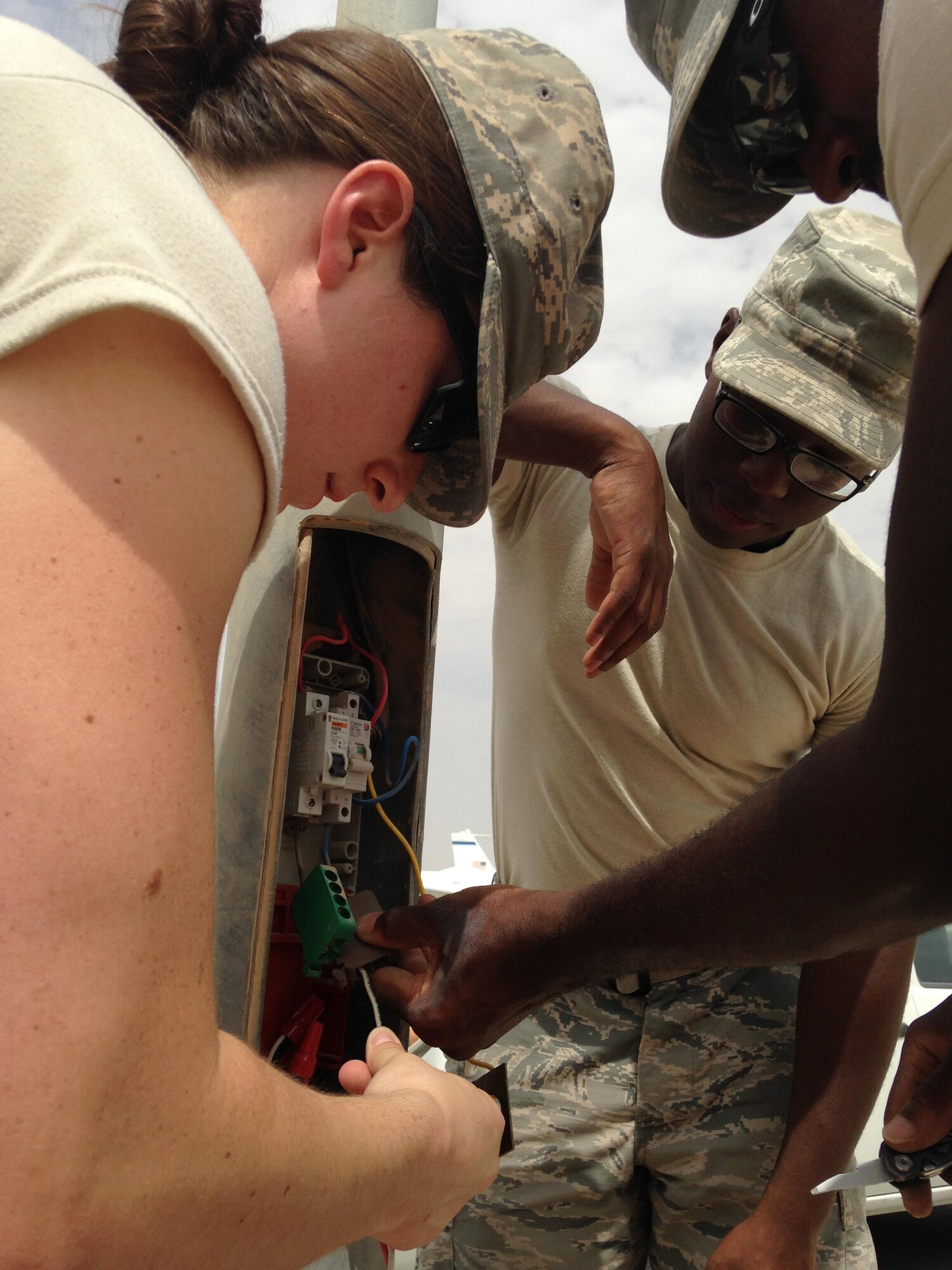 1st Lt Tawny Gardner, 379th Air Expeditionary Wing Sexual Assault Response Coordinator, re-wires a street light with SrA Dominic Jordan and
SrA George Linen, 379th Expeditionary Civil Engineering Squadron June 26, 2015 at Al Udeid Air Base, Qatar. Gardner was awarded the 2015 Sexual Assault Prevention and Response innovation award recently by the Department of Defense for her program while deployed to Al Udeid Air Base. (Courtesy Photo)
