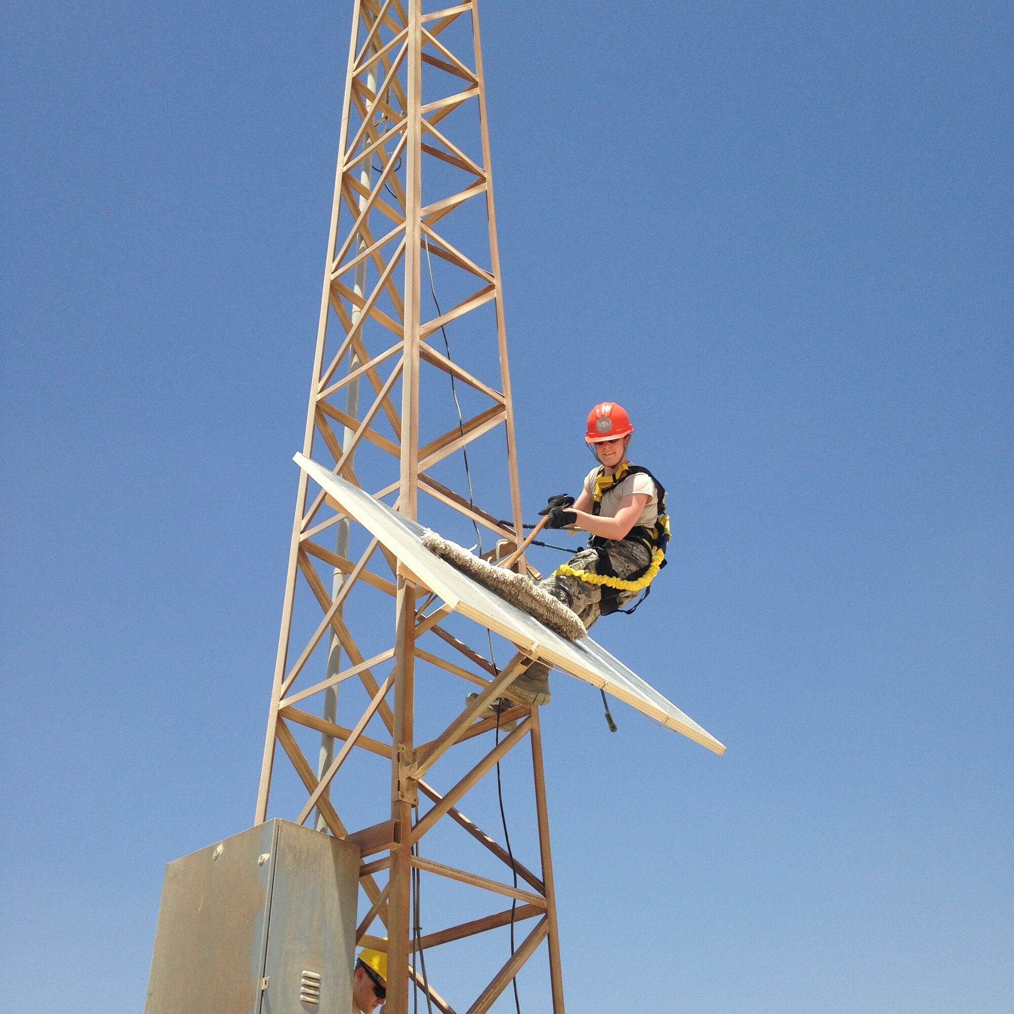 1st Lt Tawny Gardner cleans a solar panel while working with airmen from the 39th Expeditionary Communications Squadron April 20, 2015 at Al Udeid Air Base, Qatar. Gardner was awarded the 2015 Sexual Assault Prevention and Response innovation award recently by the Department of Defense for her program while deployed to Al Udeid Air Base. (Courtesy Photo)