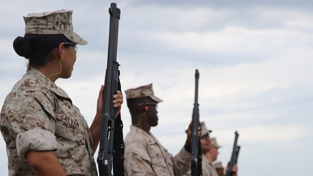 Service members wait to clear the M1014 shotgun for the next shooter during security augment force training at Marine Corps Air Station Miramar, California, June 30. This course includes members from the Marine Corps, the Navy and the Air Force.