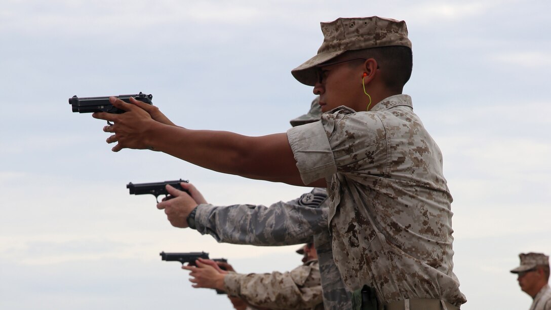 Service members shoot the M9 pistol during security augment force training at Marine Corps Air Station Miramar, California, July 1, 2015. SAF training is a two-week course that teaches service members arrest techniques and defensive tactics.