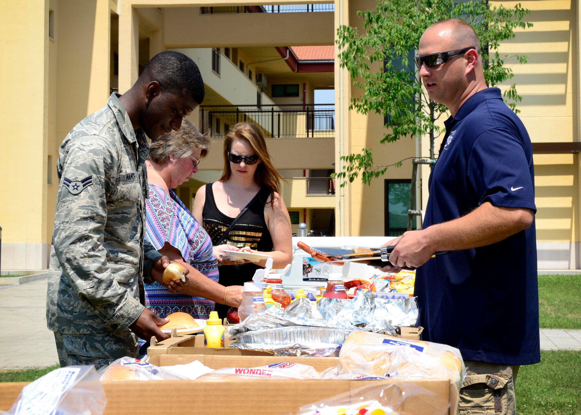 U.S. Air Force Master Sgt. John Ritz, 31st Medical Group first sergeant, serves food during a barbecue, July 2, 2015, at Aviano Air Base, Italy. The event was hosted on the dormitory campus to show appreciation for junior enlisted Airmen. (U.S. Air for photo by Senior Airman Areca T. Wilson/Released)