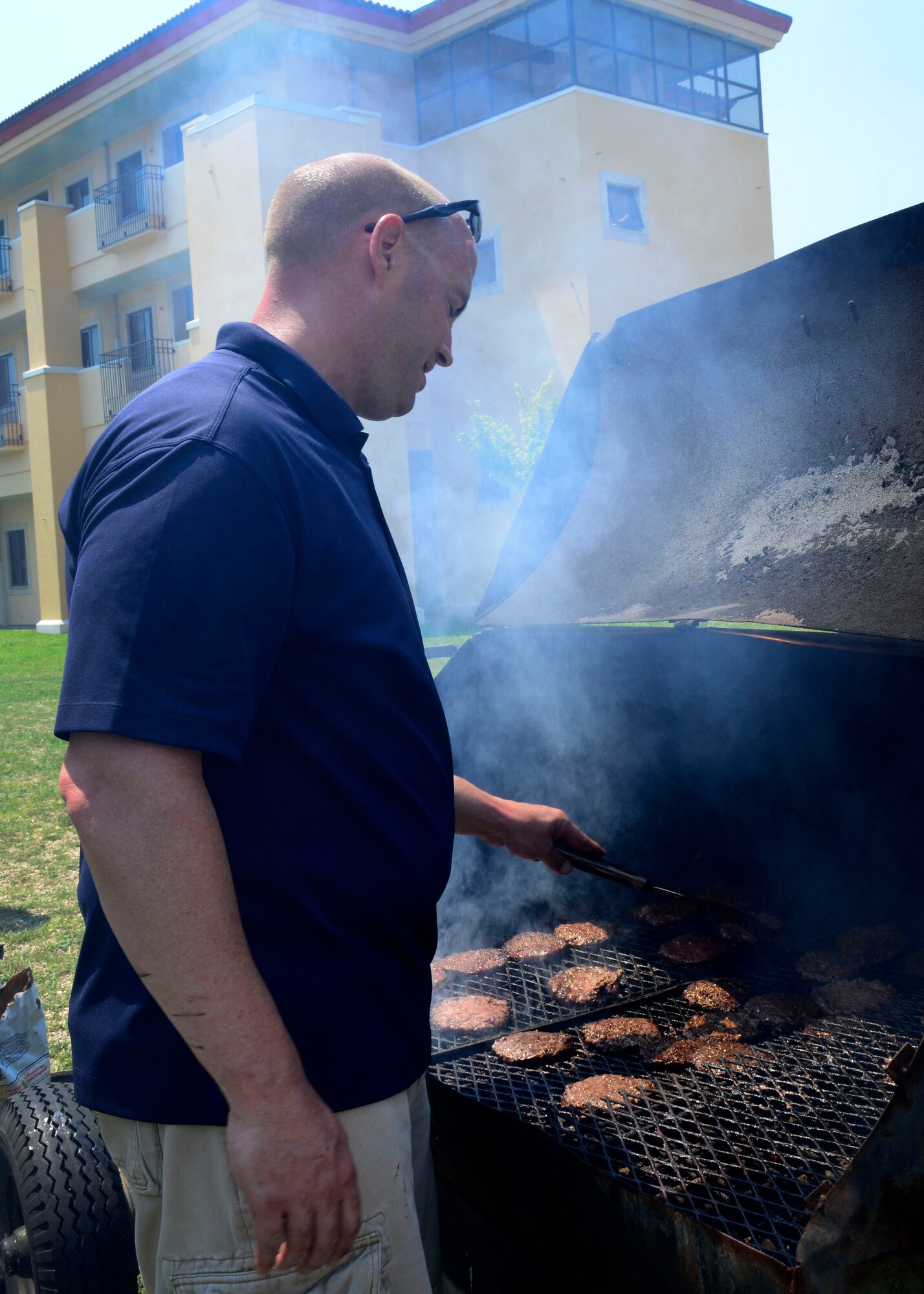 U.S. Air Force Master Sgt. Vincent Brass, 31st Logistics Readiness Squadron first sergeant, grills burgers during a barbecue, July 2, 2015, at Aviano Air Base, Italy. The event was hosted by leadership to show appreciation for junior enlisted Airmen. (U.S. Air for photo by Senior Airman Areca T. Wilson/Released)