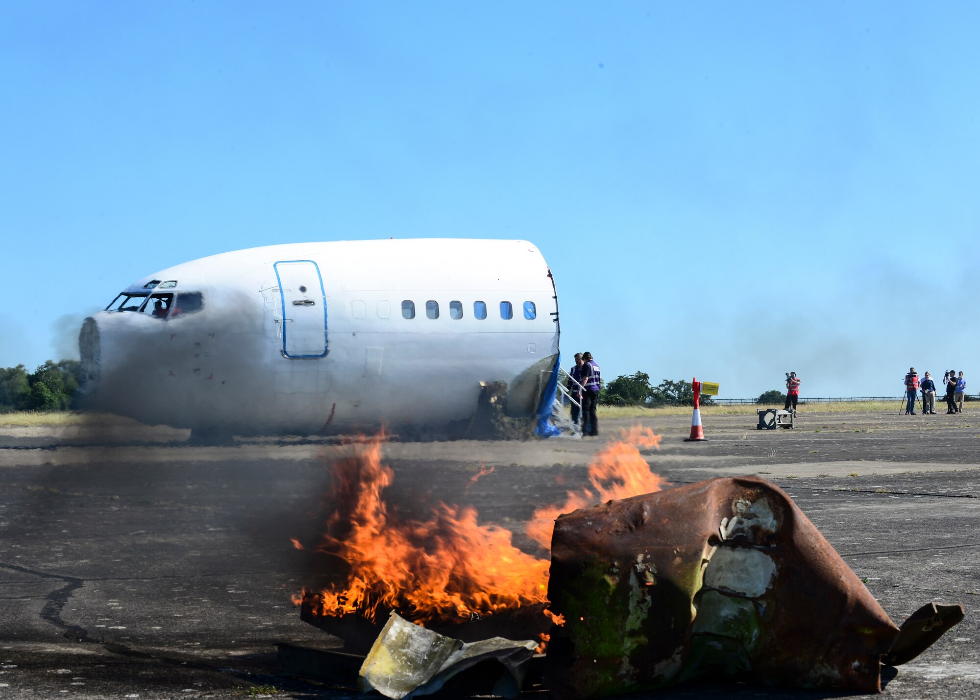 Fiery debris and a simulated air crash cover the flightline during exercise Diamond Dragon at Royal Air Force Honnington, England, June 30, 2015. Diamond Dragon is a three-day, joint forces response exercise that readies members of the U.K. Ministry of Defense, emergency response agencies and the U.S. Air Force for incidents that require help from both nations. (U.S. Air Force photo by Senior Airman Nigel Sandridge/Released)