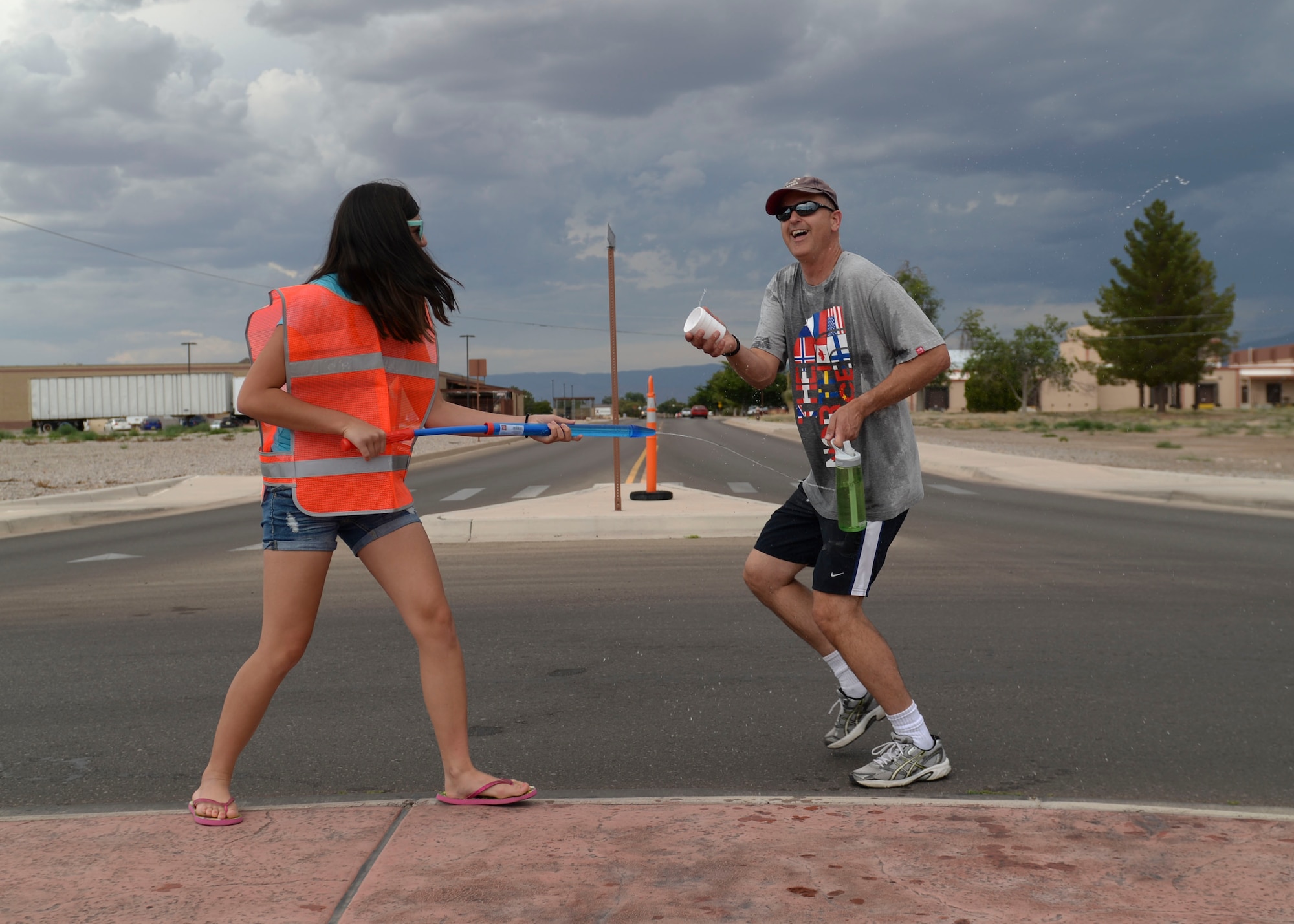 Racers are sprayed by Team Holloman members during the water fun run at Freedom Fest Independence Day celebration at Holloman Air Force Base, N.M., July 2, 2015. Freedom Fest took place in the Domenici Fitness and Sports Center parking lot and included carnival games, rides, and live music for Airmen and their families. (U.S. Air Force photo by Senior Airman Chase Cannon/Released)
