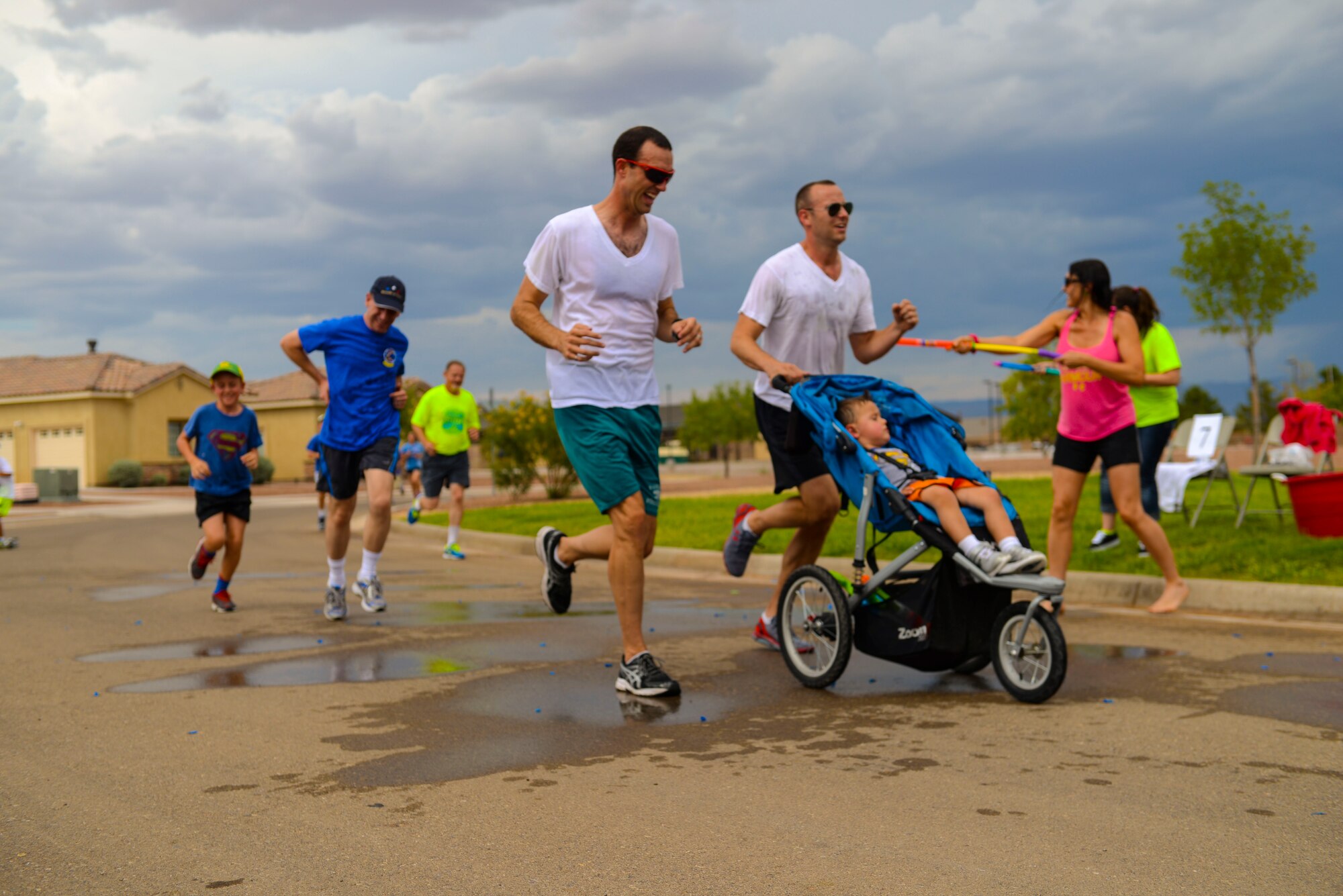 Racers are sprayed by Team Holloman members during the water fun run at Freedom Fest Independence Day celebration at Holloman Air Force Base, N.M., July 2, 2015. Freedom Fest took place in the Domenici Fitness and Sports Center parking lot and included carnival games, rides, and live music for Airmen and their families. (U.S. Air Force photo by Senior Airman Chase Cannon/Released)