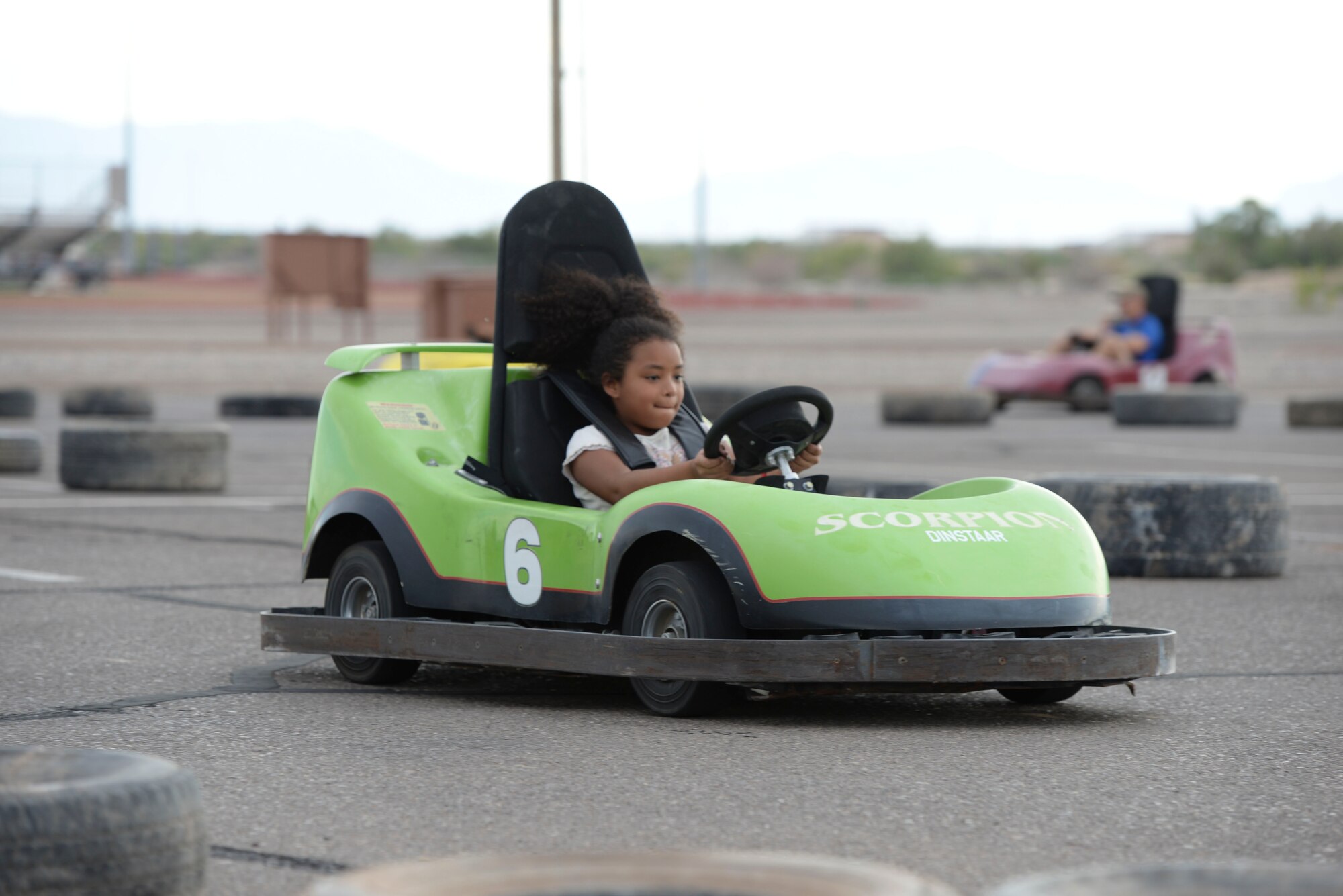 A young member of Team Holloman crosses the finish line in a go-cart during the Freedom Fest Independence Day celebration at Holloman Air Force Base, N.M., July 2, 2015. Freedom Fest took place in the Domenici Fitness and Sports Center parking lot and included carnival games, rides, and live music for Airmen and their families. (U.S. Air Force photo by Staff Sgt. E’Lysia A. Wray/Released)