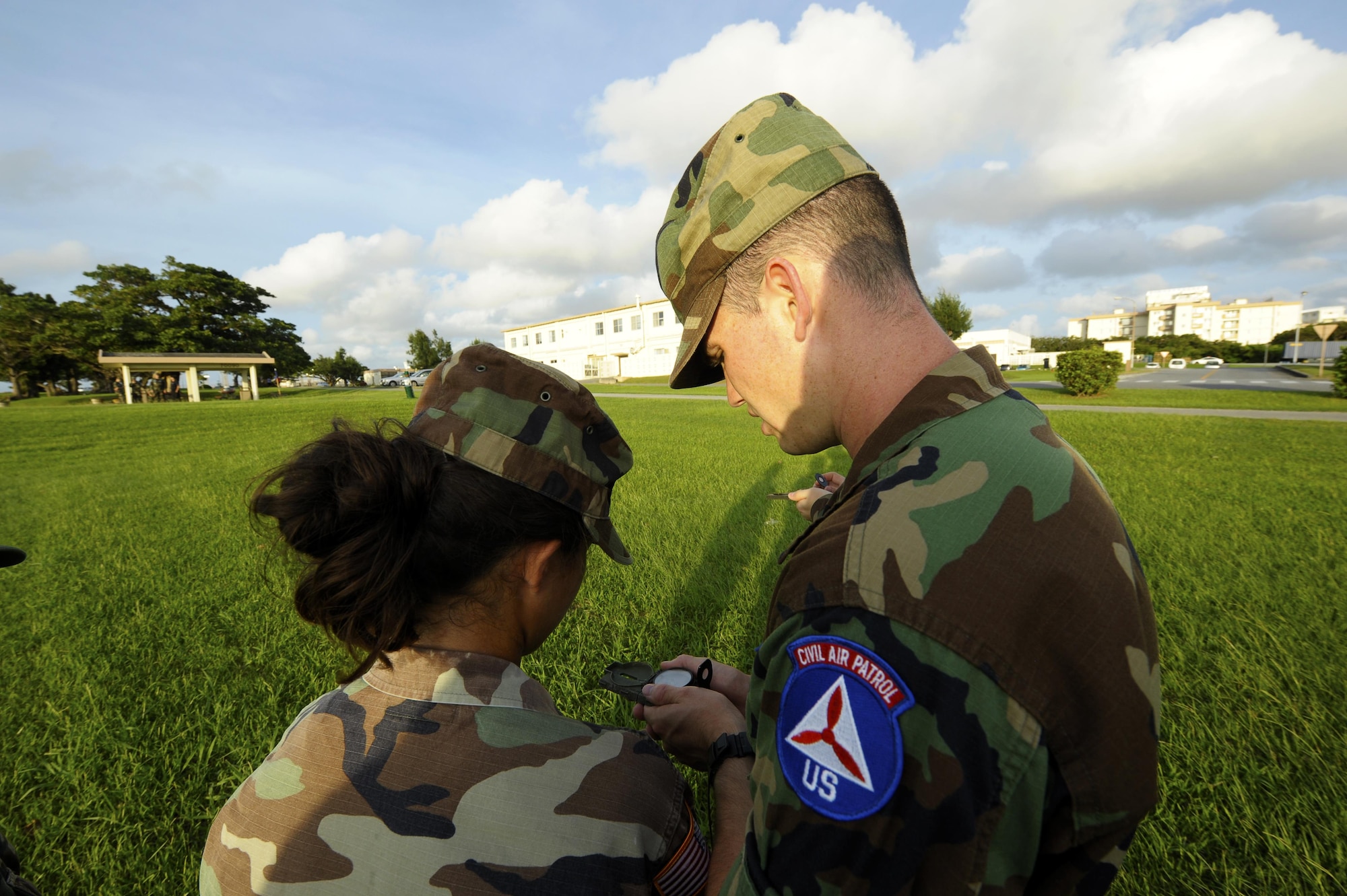 Senior Airman Chance Sheek (right), an 18th Logistics Readiness Squadron vehicle operator, teaches a young cadet in the Civil Air Patrol how to use a compass on Kadena Air Base, Japan, June 26, 2015. Sheek is now a first lieutenant in the CAP and is held responsible for ground emergency training such as search and rescue. (U.S. Air Force photo/Airman 1st Class Zackary A. Henry)