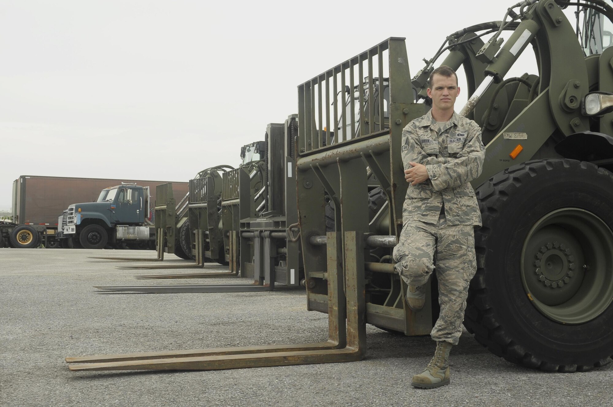 Senior Airman Chance Sheek, an 18th Logistics Readiness Squadron vehicle operations vehicle operator, stands next to forklifts he works with every day on Kadena Air Base, Japan, June 29, 2015. During the week, Sheek does anything from driving around distinguished visitors to loading trucks, but as a member of the Civil Air Patrol, he leads cadets through search and rescue exercises and teaches them skills like using compasses, land navigation, radio usage and basic medical skills (U.S. Air Force photo/Airman 1st Class Zackary A. Henry)