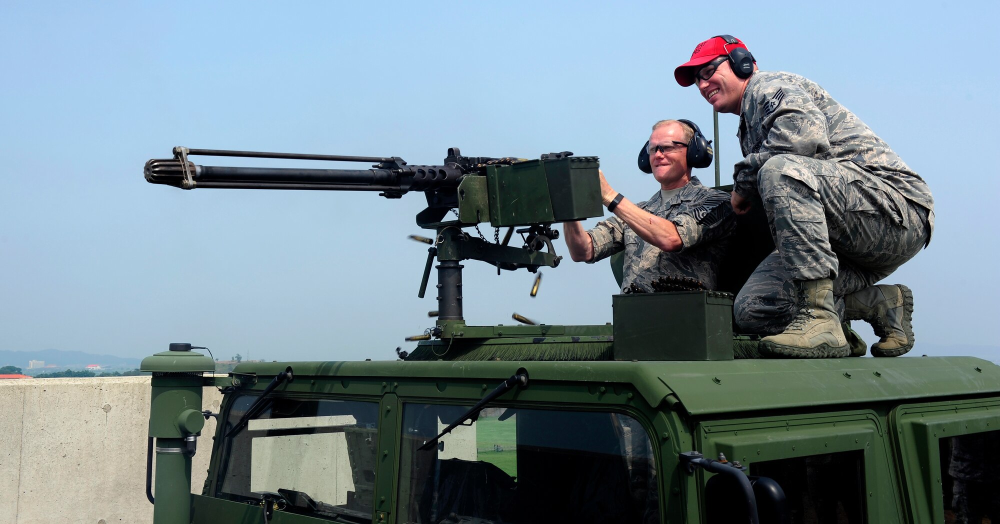 Chief Master Sgt. of the Air Force James A. Cody fires an M250 caliber machine gun as he is supervised by Staff Sgt. Brandon Johnson, 8th Security Forces Squadron combat arms instructor, as part of an immersion tour at Kunsan Air Base, Republic of Korea, July 2, 2015. Cody engaged with Wolf Pack Airmen to answer questions and give insight on key Air Force topics and changes. (U.S. Air Force photo by Staff Sgt. Nick Wilson/Released)