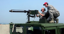 Chief Master Sgt. of the Air Force James A. Cody fires an M250 caliber machine gun as he is supervised by Staff Sgt. Brandon Johnson, 8th Security Forces Squadron combat arms instructor, as part of an immersion tour at Kunsan Air Base, Republic of Korea, July 2, 2015. Cody engaged with Wolf Pack Airmen to answer questions and give insight on key Air Force topics and changes. (U.S. Air Force photo by Staff Sgt. Nick Wilson/Released)