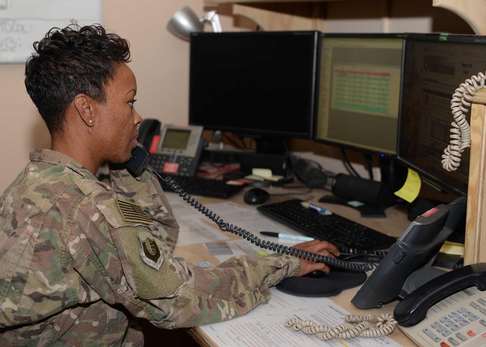 U.S. Air Force Tech. Sgt. Samantha Morgan, 455th Air Expeditionary Wing Command Post non-commissioned officer in charge of operations, takes down information before sending out mission critical information July 6, 2015, at Bagram Airfield, Afghanistan. Morgan and her team are responsible for initiating wing recalls, relaying weather and inbound attack notifications to the base as well as work with aircrews and other various agencies in keeping the base abreast on important information. (U.S. Air Force photo by Senior Airman Cierra Presentado/Released)