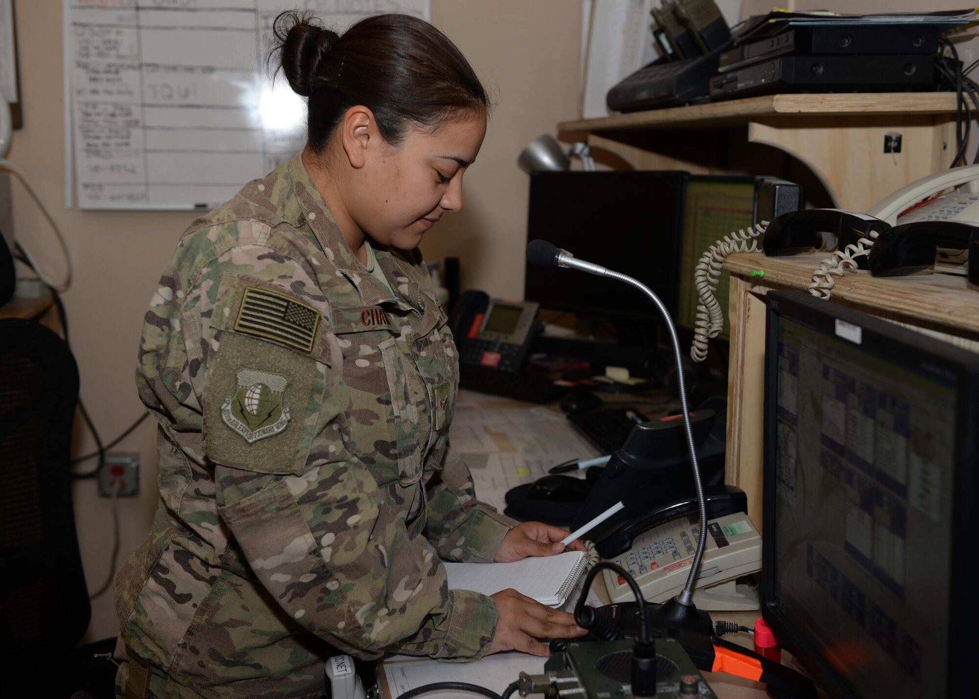 U.S. Air Force Airman 1st Class Judy Chavez-Colorado, 455th Air Expeditionary Wing Command Post emergency actions controller, collects information July 6, 2015, at Bagram Airfield, Afghanistan. Chavez-Colorado and her team are responsible for initiating wing recalls, relaying weather and inbound attack notifications to the base as well as work with aircrews and other various agencies in keeping the base abreast on important information. (U.S. Air Force photo by Senior Airman Cierra Presentado/Released)