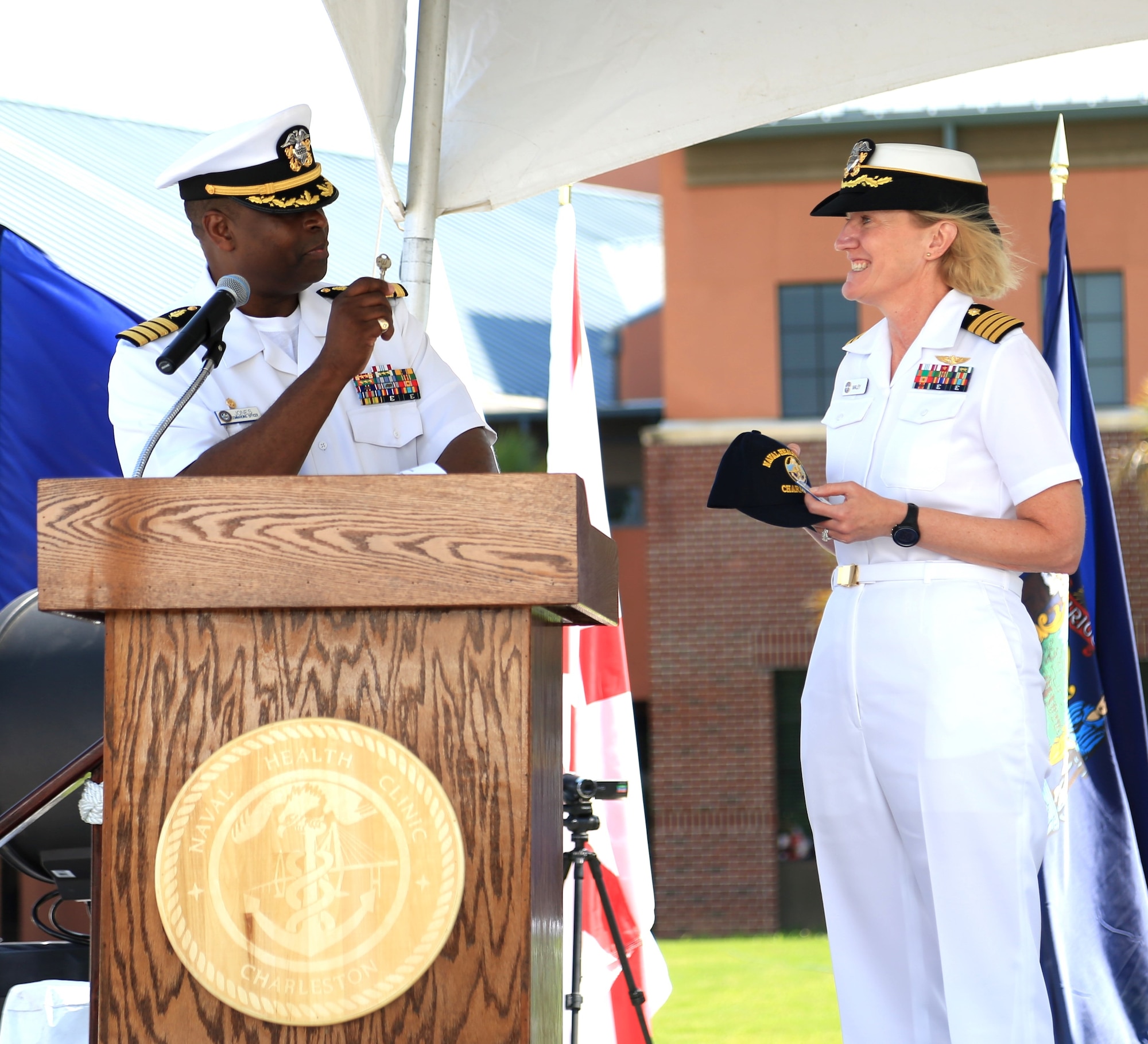 Captain Marvin Jones, outgoing commanding officer of Naval Health Clinic Charleston, presents Capt. Elizabeth Maley, incoming commanding officer, the key to NHCC as he relinquishes command to Maley during a change of command ceremony June 26, 2015 at the clinic on Joint Base Charleston - Weapons Station. Jones, a healthcare administrator, is
leaving NHCC to be the base commander at Naval Support Activity in Bethesda, MD. Maley, an occupational health physician, comes to NHCC from Naval Health Clinic Cherry Point, N.C., where she served as executive officer for two years. (Navy photo/ Hospitalman Adrienne Quinter)
