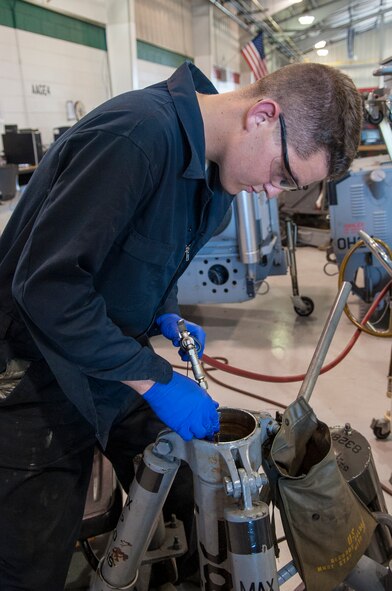 Airman 1st Class Stephen Hallock, 4th Equipment Maintenance Squadron aerospace ground equipment technician, places a hose into an aircraft wing jack to remove the oil, June 22, 2015, at Seymour Johnson Air Force Base, North Carolina. AGE is responsible for more than 600 pieces of equipment used for flightline operations to keep the more than 90 F-15E Strike Eagles flying. (U.S. Air Force photo/Airman Shawna L. Keyes) 