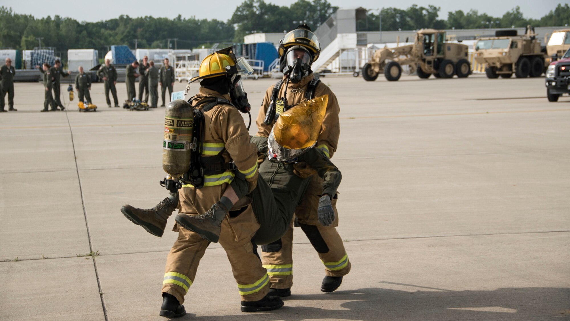 Firefighters assigned to the 180th Fire Department carry an 89th Airlift Squadron air crew member during a fire exercise June 7. (Air Force photo by Senior Airman Devin Long)