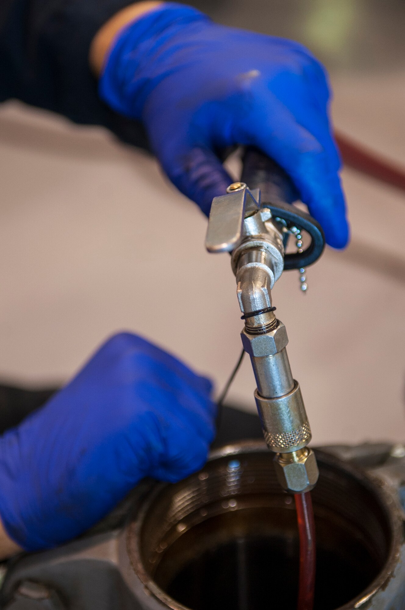 Airman 1st Class Stephen Hallock, 4th Equipment Maintenance Squadron aerospace ground equipment technician, removes oil from an aircraft wing jack, June 22, 2015, at Seymour Johnson Air Force Base, North Carolina. AGE Airmen perform maintenance and inspections on all the ground equipment used throughout all four aircraft maintenance units. (U.S. Air Force photo/Airman Shawna L. Keyes)