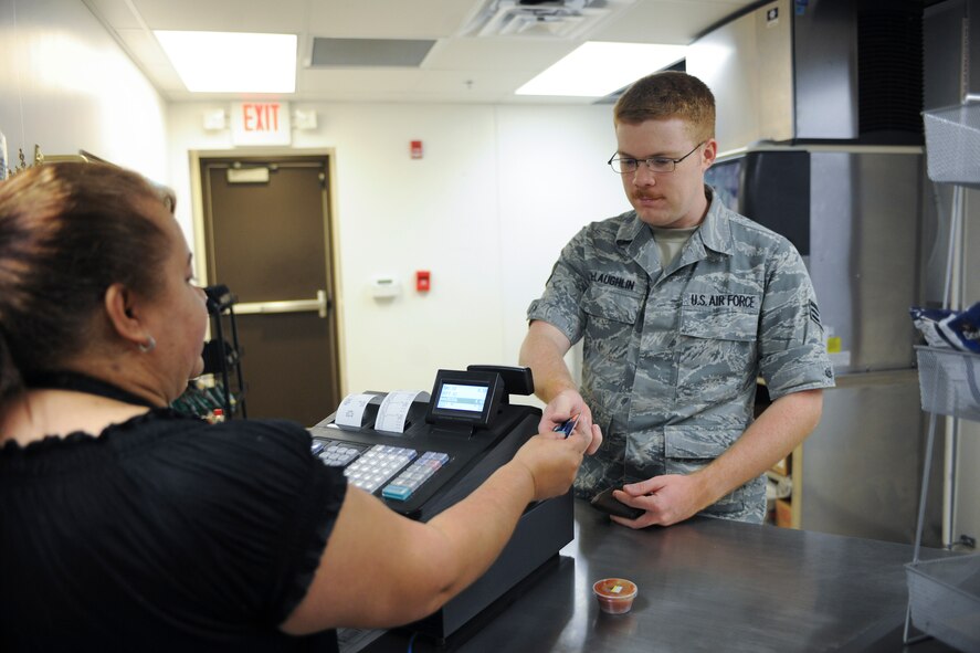 U.S. Air Force Senior Airman Lugh McLaughlin, 23d Communications Squadron network infrastructure technician, purchases a meal from Candy Del Valle, 23d Force Support Squadron Turn N’ Burn Flight Kitchen food service worker, July 1, 2015, at Moody Air Force Base, Ga. The Turn N’ Burn Flight Kitchen offers breakfast from 6:30 a.m. to 9 a.m. and lunch from 11 a.m. to 1 p.m. (U.S. Air Force photo by Senior Airman Sandra Marrero/Released) 