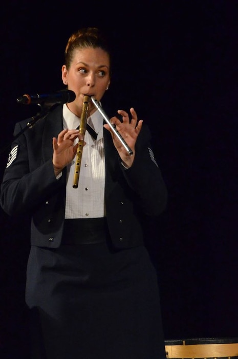 Technical Sgt. Julia Brundage tries playing two of her many instruments at  once. (U.S. Air Force Photo by Senior Master Sgt. Bob Kamholz/released)
