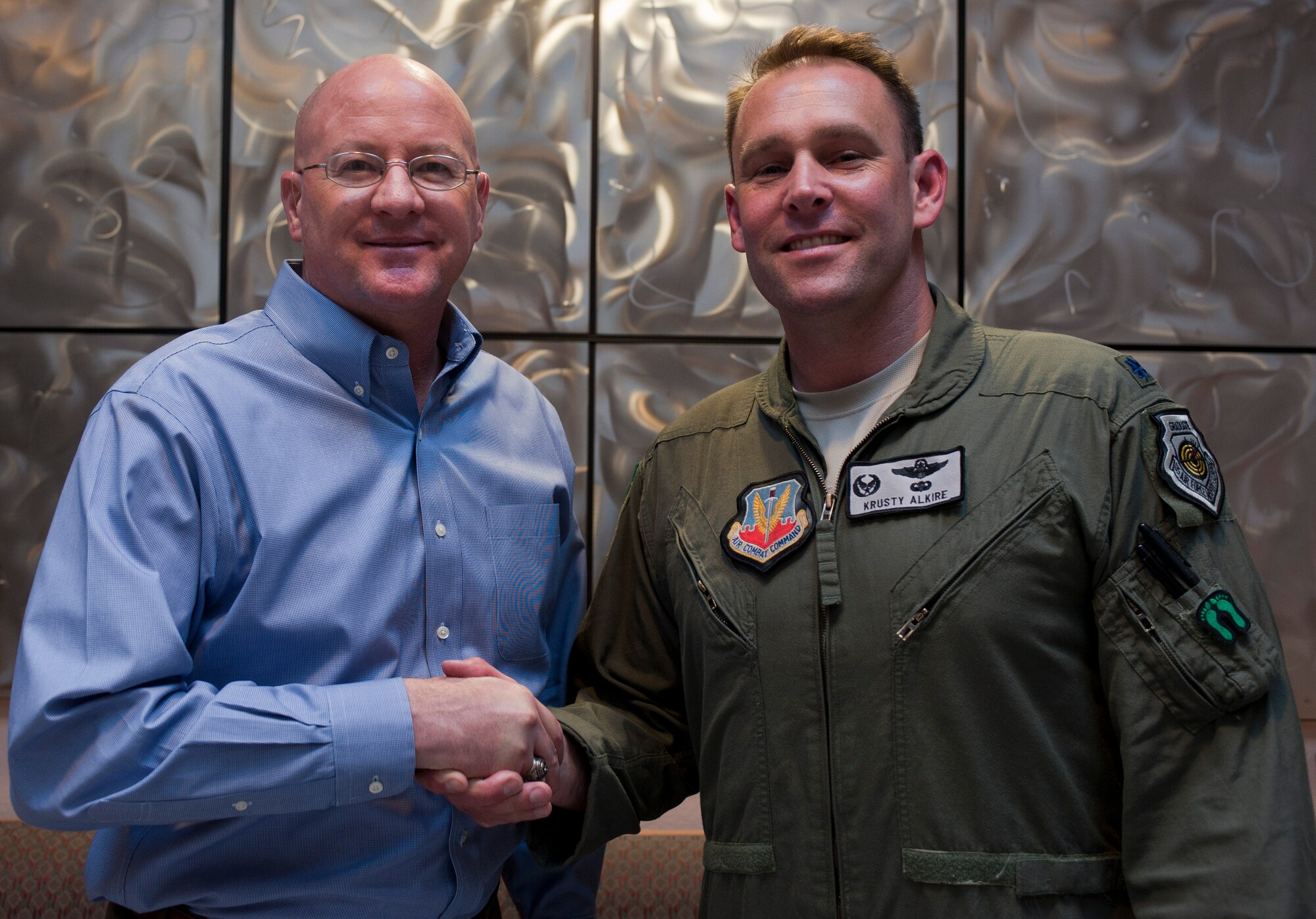 Retired Col. Tim “Ghandi” Healy, left, 34th Weapons Squadron commander from 1999-2001, shakes hands with Lt. Col. Joe “Krusty” Alkire, 34th WPS commander, during the 34th WPS’ 20th anniversary celebration and reunion at the Desert Oasis Club on Nellis Air Force Base, Nev., June 25, 2015. The purpose of the reunion was to honor the squadron’s members who’ve helped make the unit what it is today, and to bridge the gap between then and now. (U.S. Air Force photo by Airman 1st Class Mikaley Towle)