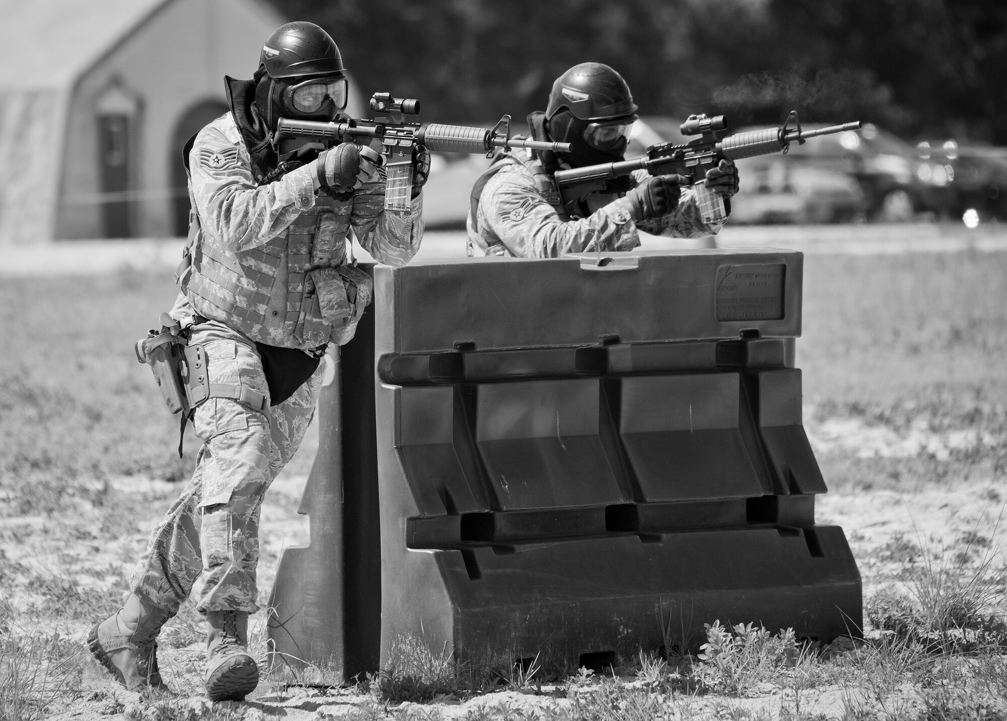 A 96th Security Forces Squadron Airman advances forward during a shoot, move and communicate drill in June at Eglin Air Force Base, Fla.  The mandatory training requirement is in addition to annual weapons qualification training.  The exercise consists of Airmen firing simmunition ammo while advancing toward, away from and to the side of a target.  This is followed by a building sweep and clear drill.  The Defenders perform the highly kinetic training at Eglin’s Base Tango range.  The range was previously used for security forces pre-deployment training.  (U.S. Air Force photo/Samuel King Jr.)
