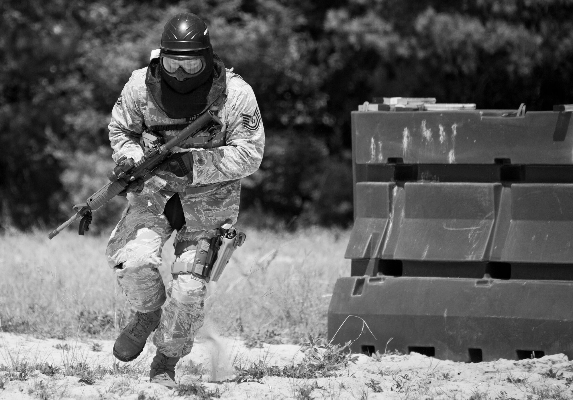 A 96th Security Forces Squadron Airman advances forward during a shoot, move and communicate drill in June at Eglin Air Force Base, Fla.  The mandatory training requirement is in addition to annual weapons qualification training.  The exercise consists of Airmen firing simmunition ammo while advancing toward, away from and to the side of a target.  This is followed by a building sweep and clear drill.  The Defenders perform the highly kinetic training at Eglin’s Base Tango range.  The range was previously used for security forces pre-deployment training.  (U.S. Air Force photo/Samuel King Jr.)