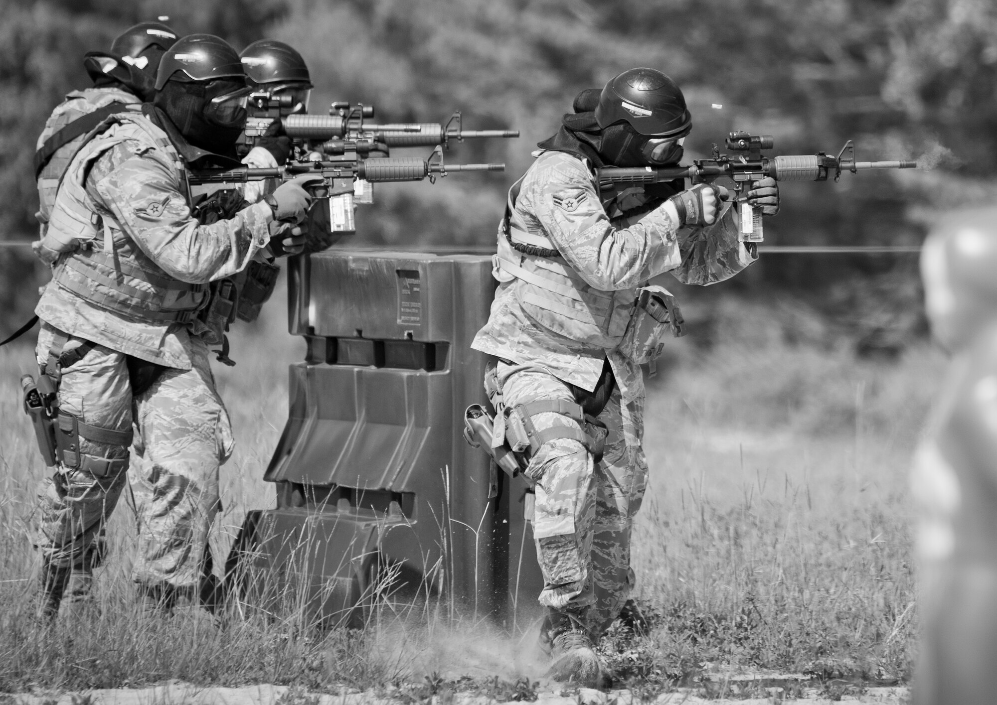 A team of 96th Security Forces Squadron Airmen perform a side-advancing movement during a shoot, move and communicate drill in June at Eglin Air Force Base, Fla.  The mandatory training requirement is in addition to annual weapons qualification training.  The exercise consists of Airmen firing simmunition ammo while advancing toward, away from and to the side of a target.  This is followed by a building sweep and clear drill.  The Defenders perform the highly kinetic training at Eglin’s Base Tango range.  The range was previously used for security forces pre-deployment training.  (U.S. Air Force photo/Samuel King Jr.)