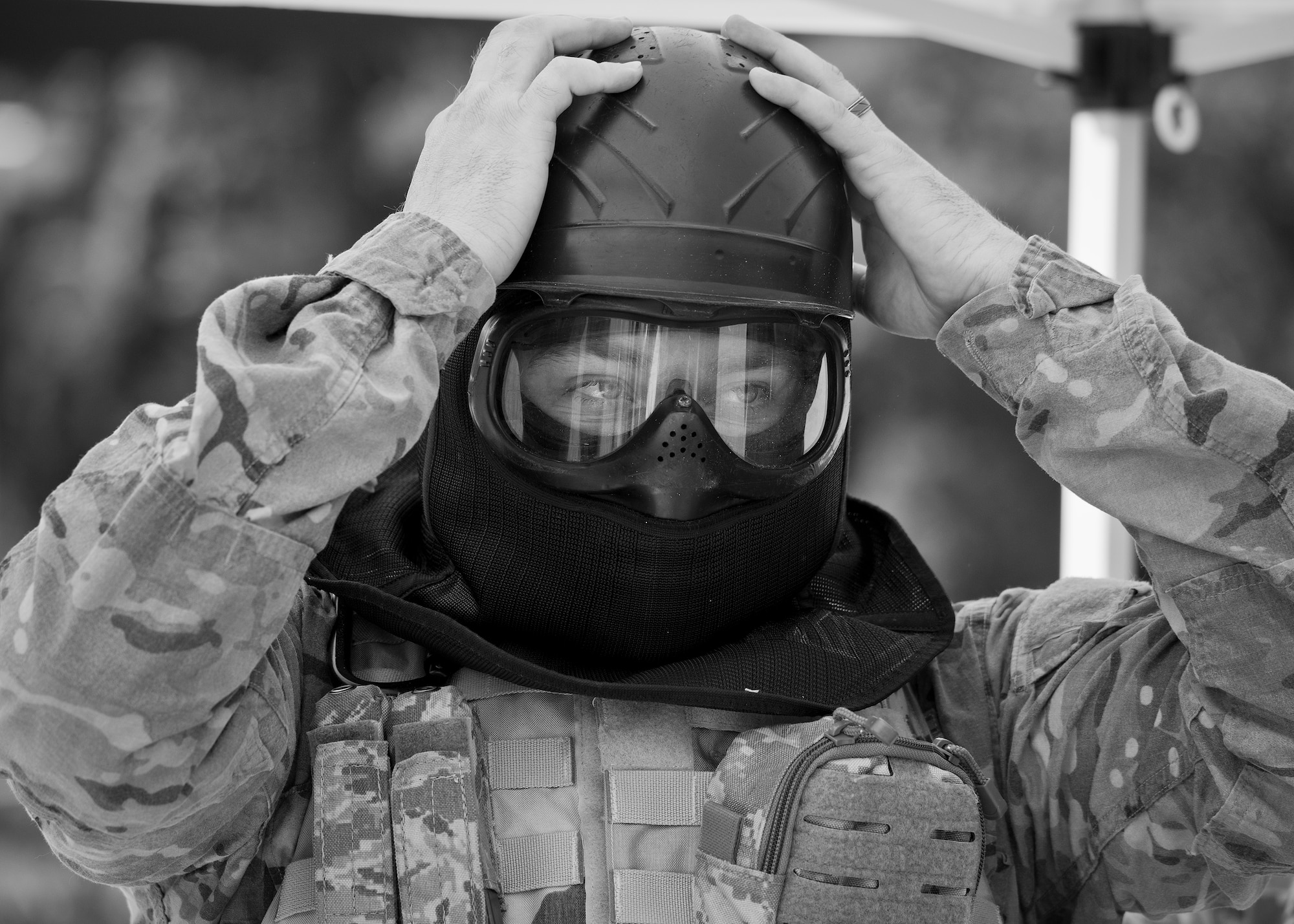 A 96th Security Forces Squadron Airman secures his helmet prior to a shoot, move and communicate drill in June at Eglin Air Force Base, Fla.  The mandatory training requirement is in addition to annual weapons qualification training.  The exercise consists of Airmen firing simmunition ammo while advancing toward, away from and to the side of a target.  This is followed by a building sweep and clear drill.  The Defenders perform the highly kinetic training at Eglin’s Base Tango range.  The range was previously used for security forces pre-deployment training.  (U.S. Air Force photo/Samuel King Jr.)