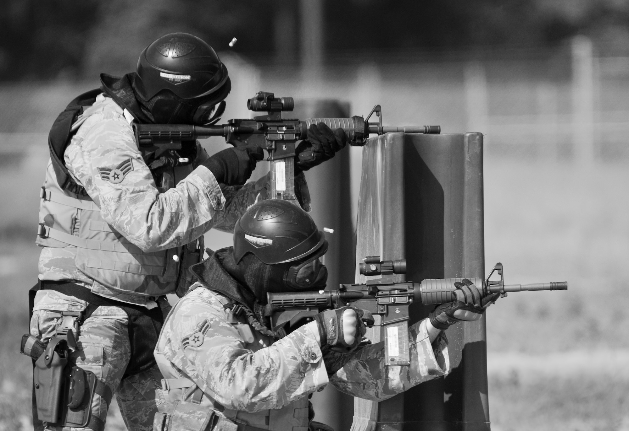 Simmunition rounds pop out of 96th Security Forces Squadron Airmen’s M-4 rifles as they fire downrange during a shoot, move and communicate drill in June at Eglin Air Force Base, Fla.  The mandatory training requirement is in addition to annual weapons qualification training.  The exercise consists of Airmen firing simmunition ammo while advancing toward, away from and to the side of a target.  This is followed by a building sweep and clear drill.  The Defenders perform the highly kinetic training at Eglin’s Base Tango range.  The range was previously used for security forces pre-deployment training.  (U.S. Air Force photo/Samuel King Jr.)